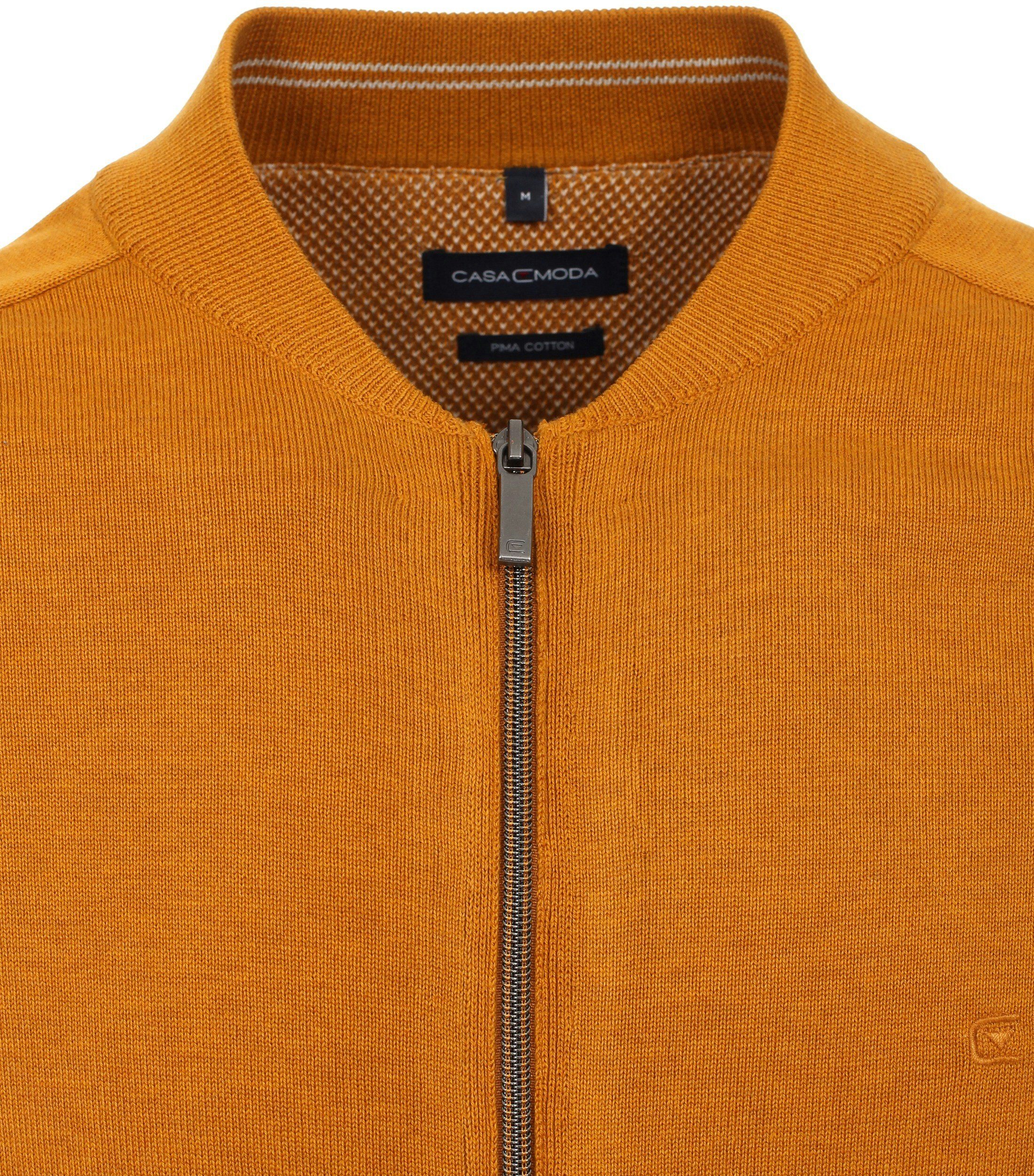 Das Model trägt eine Strickjacke im uni Muster in der Farbe Senfgelb