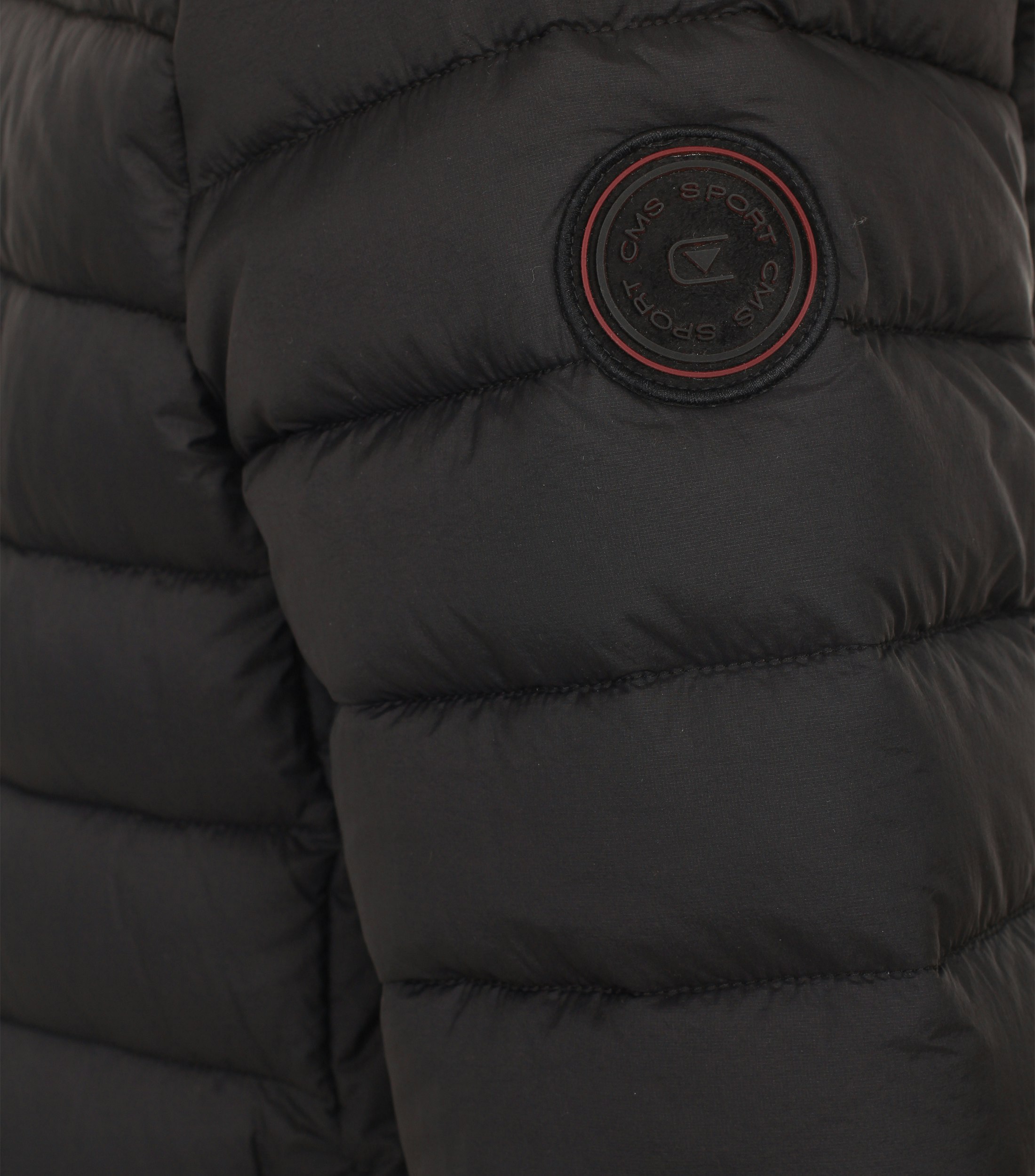 Das Model trägt eine Jacke im uni Muster in der Farbe Schwarz