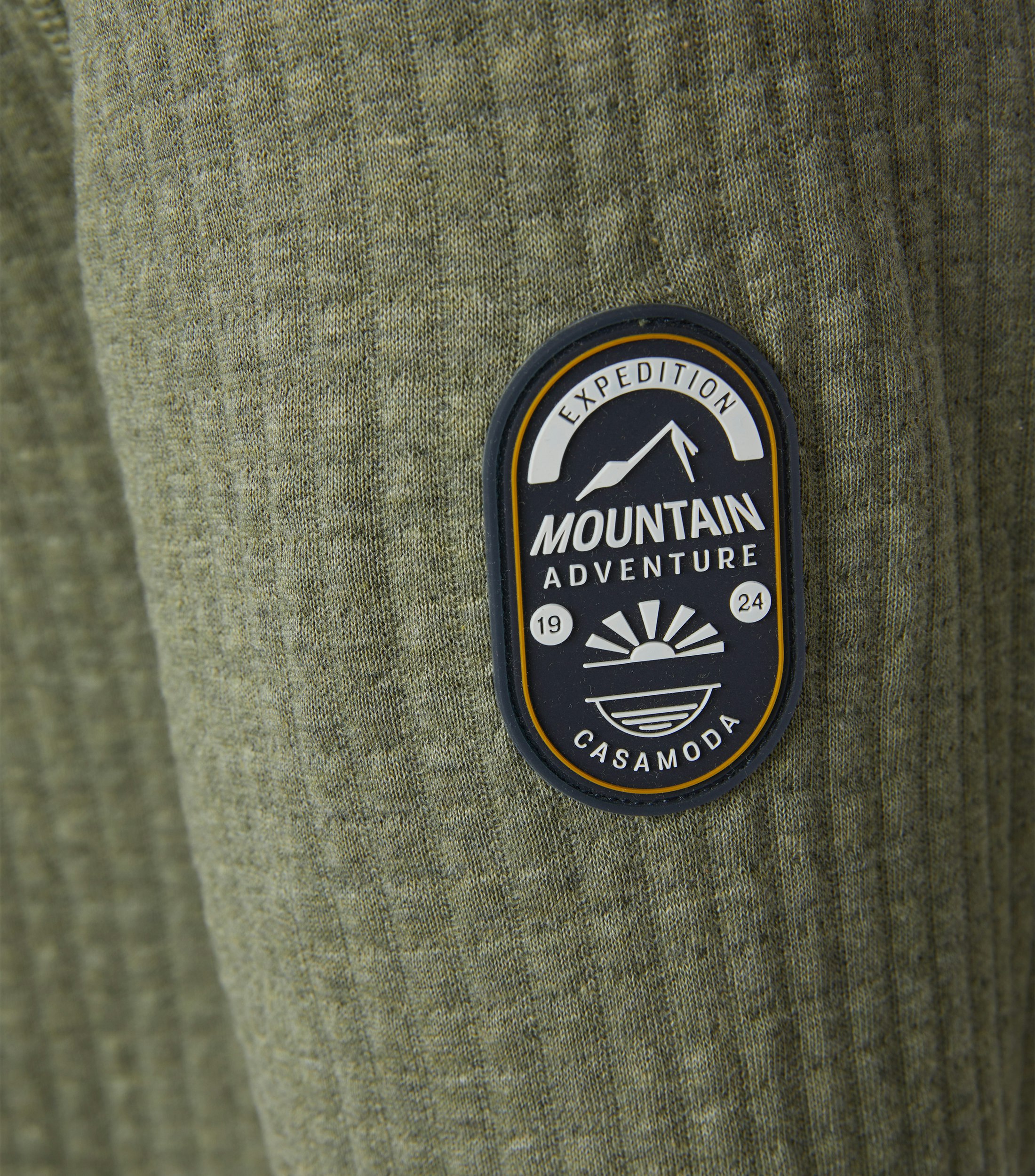 Das Model trägt ein Sweatshirt im uni Muster in der Farbe Grün