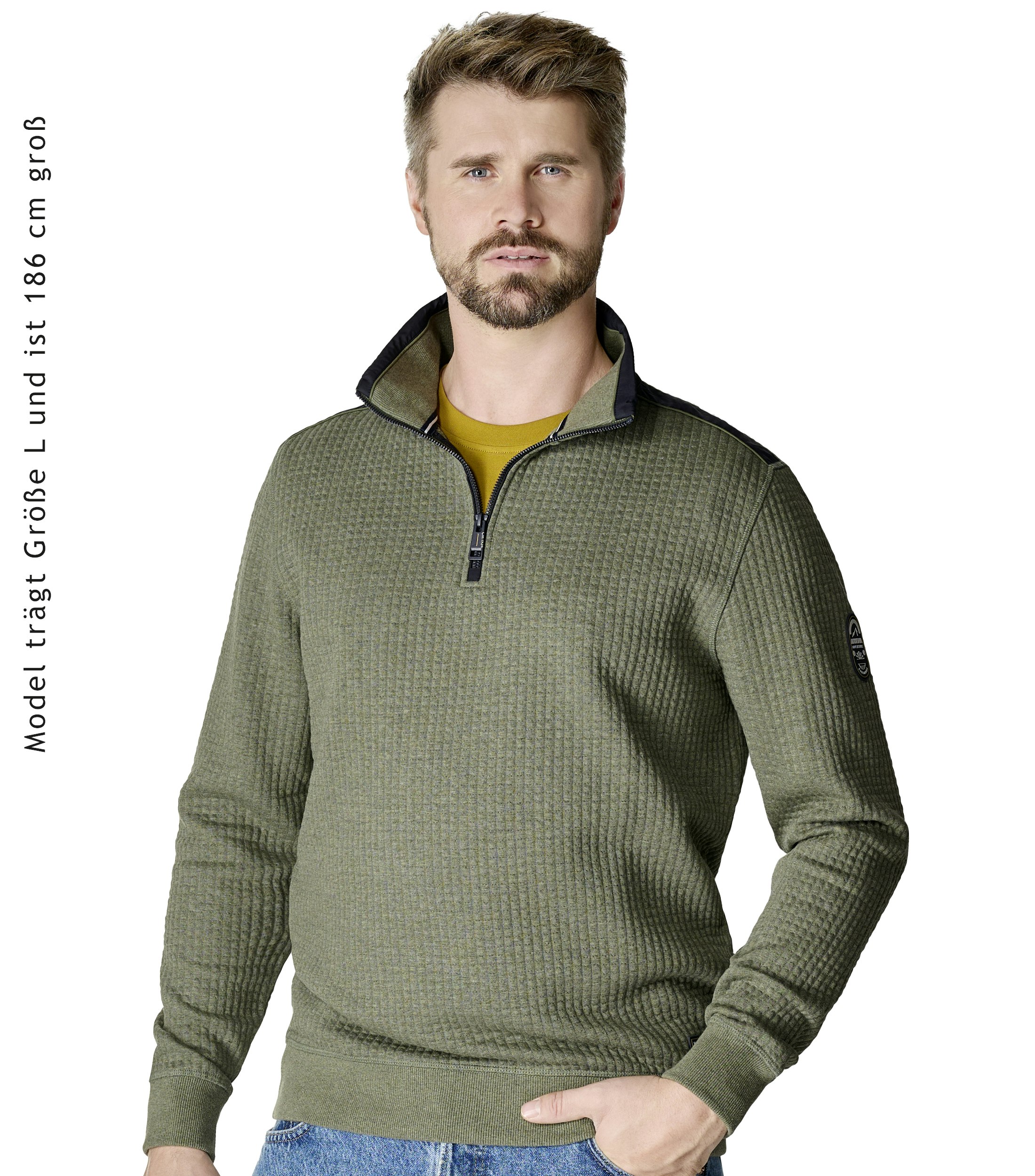 Das Model trägt ein Sweatshirt im uni Muster in der Farbe Grün