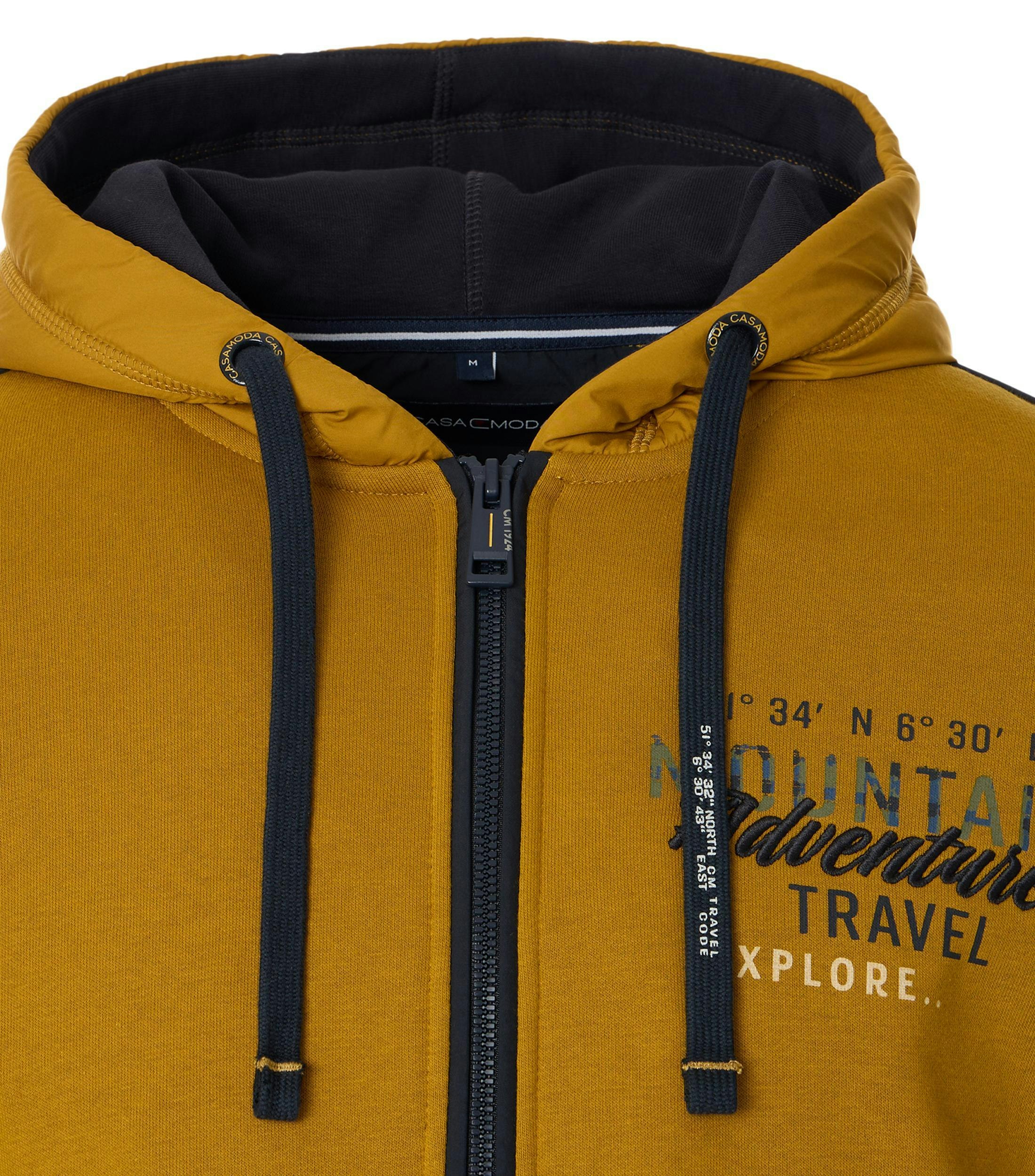 Das Model trägt ein Sweatshirt im uni Muster in der Farbe Senfgelb