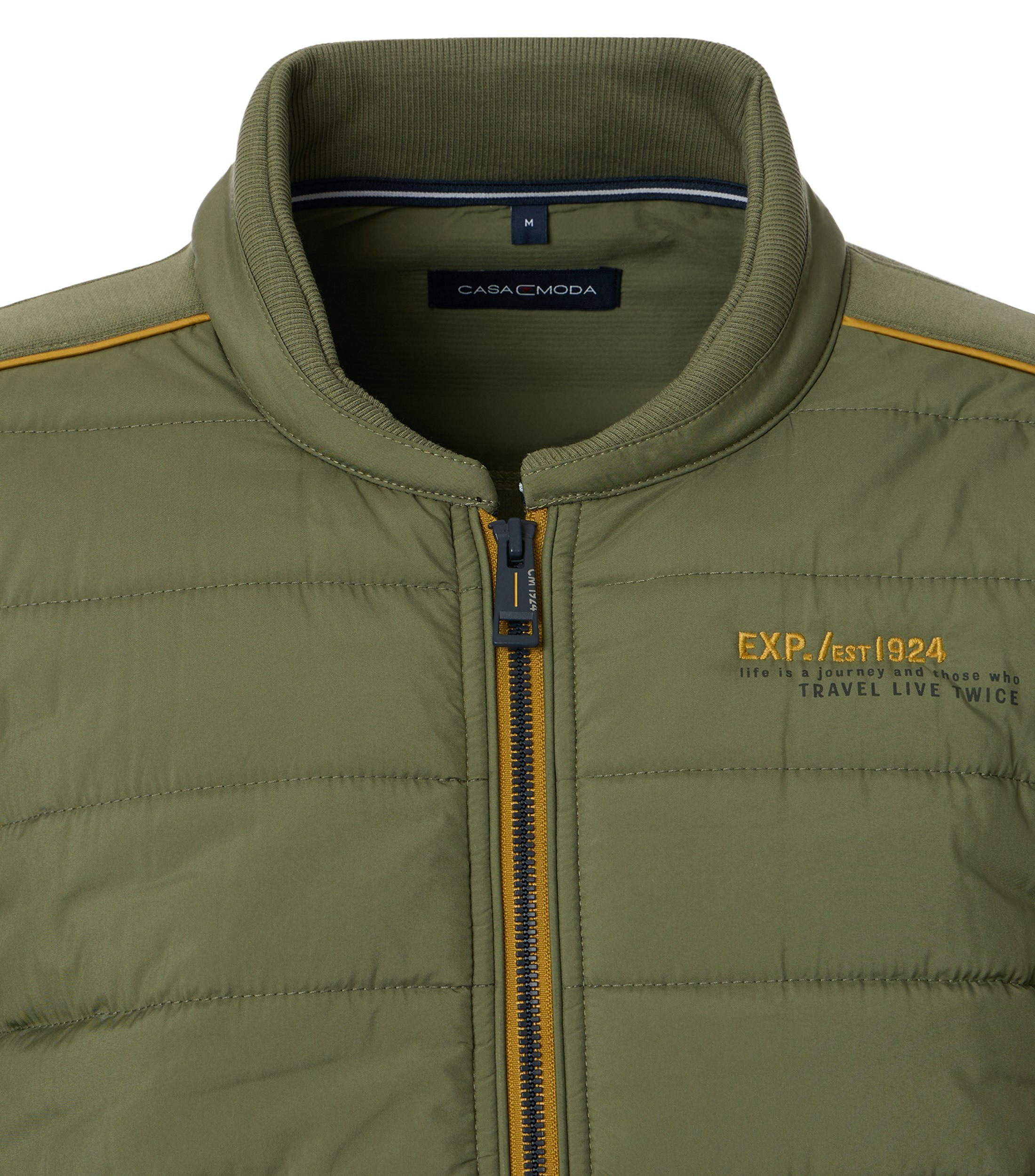 Das Model trägt eine Sweatjacke im uni Muster in der Farbe Grün