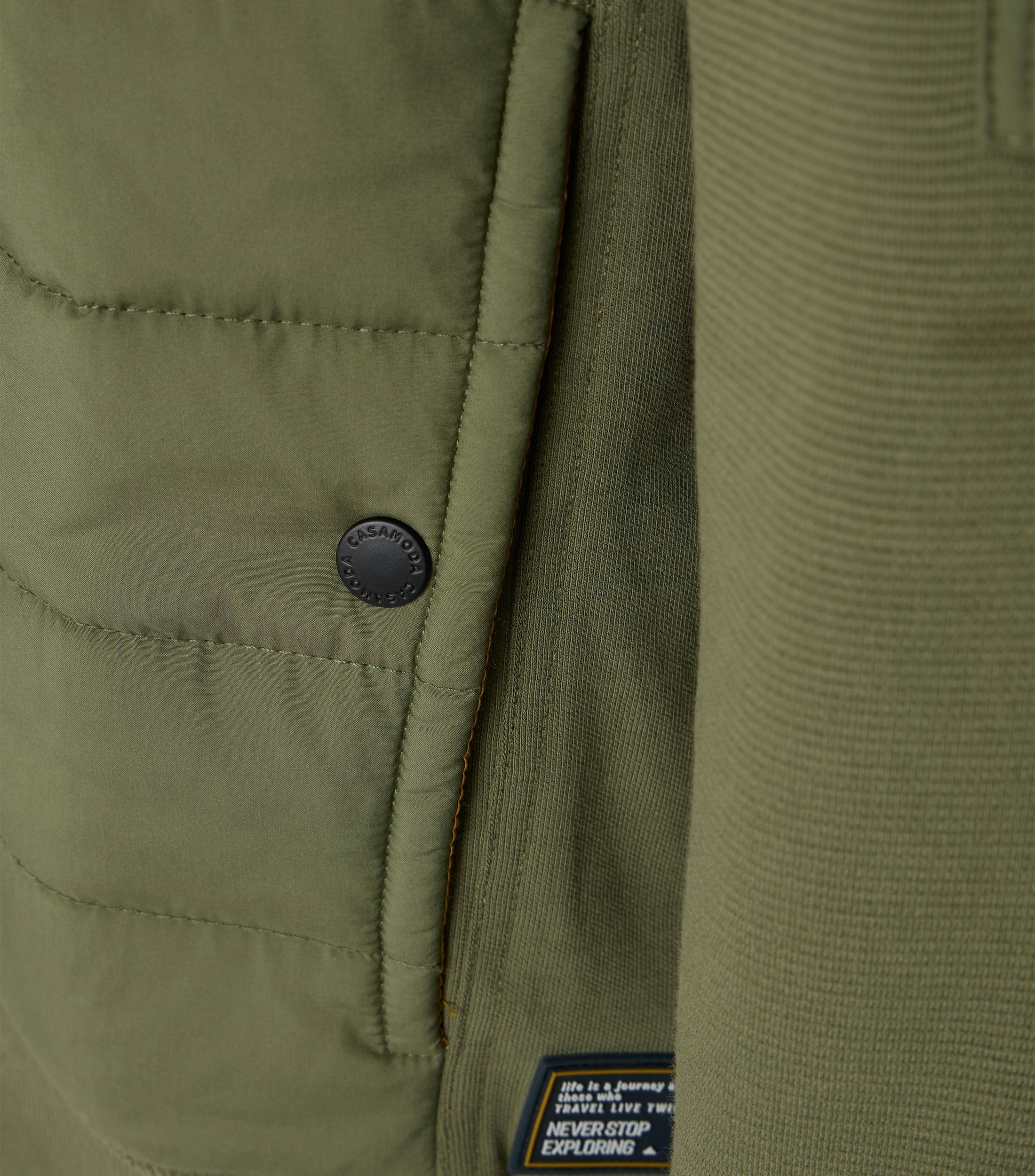 Das Model trägt eine Sweatjacke im uni Muster in der Farbe Grün