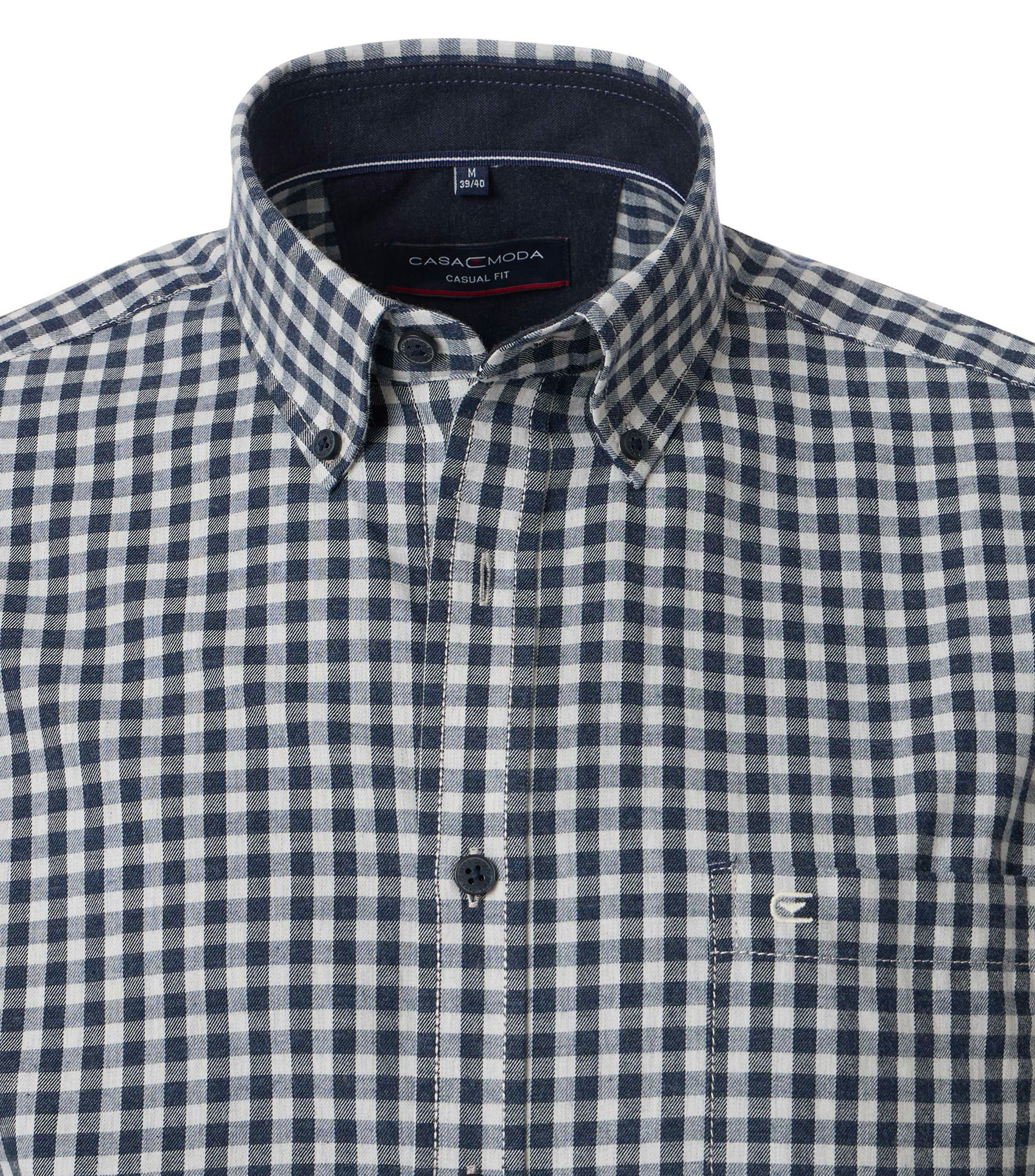 Das Model trägt ein Freizeithemd im kariert Muster in der Farbe Hellblau