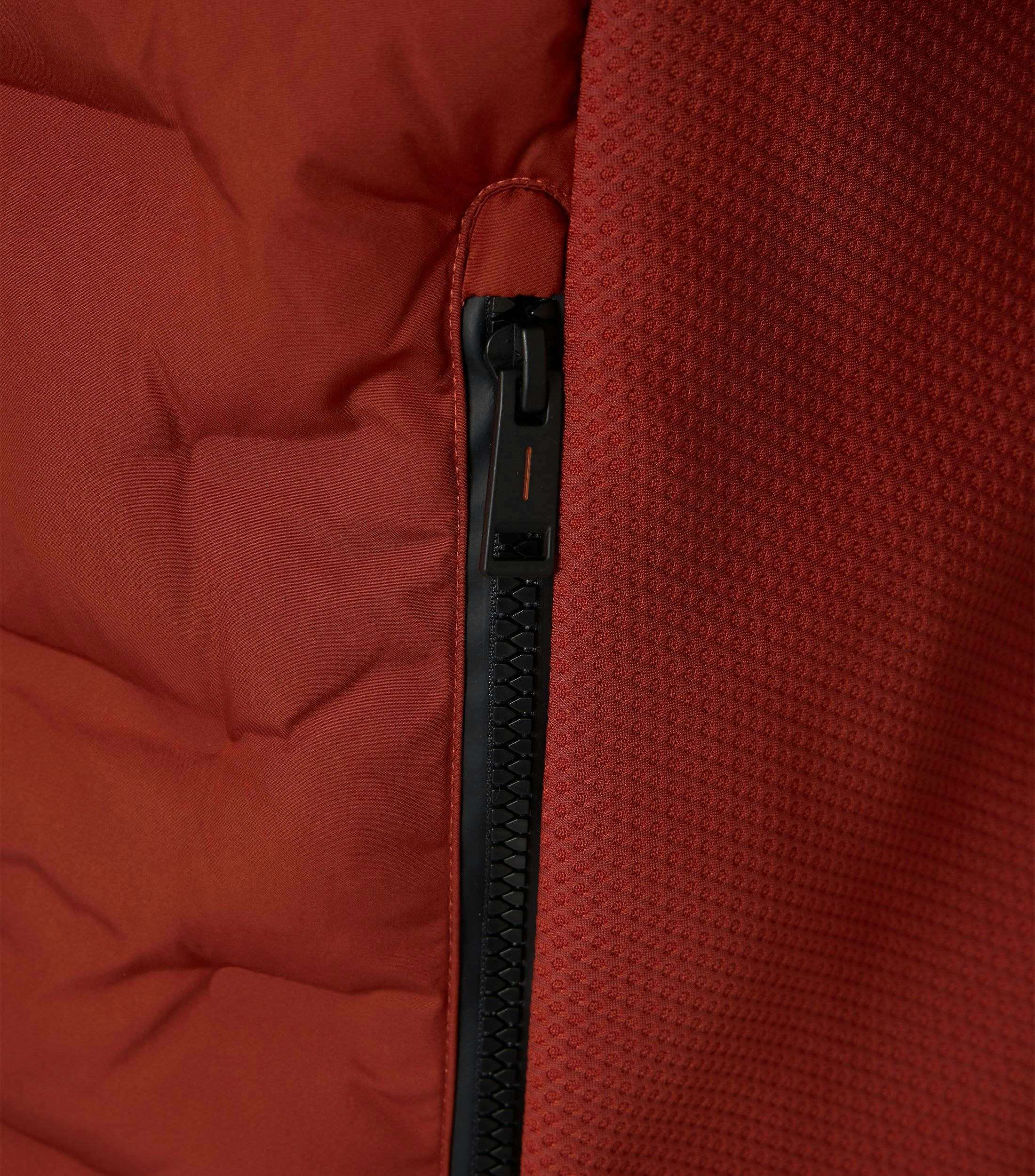 Das Model trägt eine Weste im uni Muster in der Farbe Dunkelorange