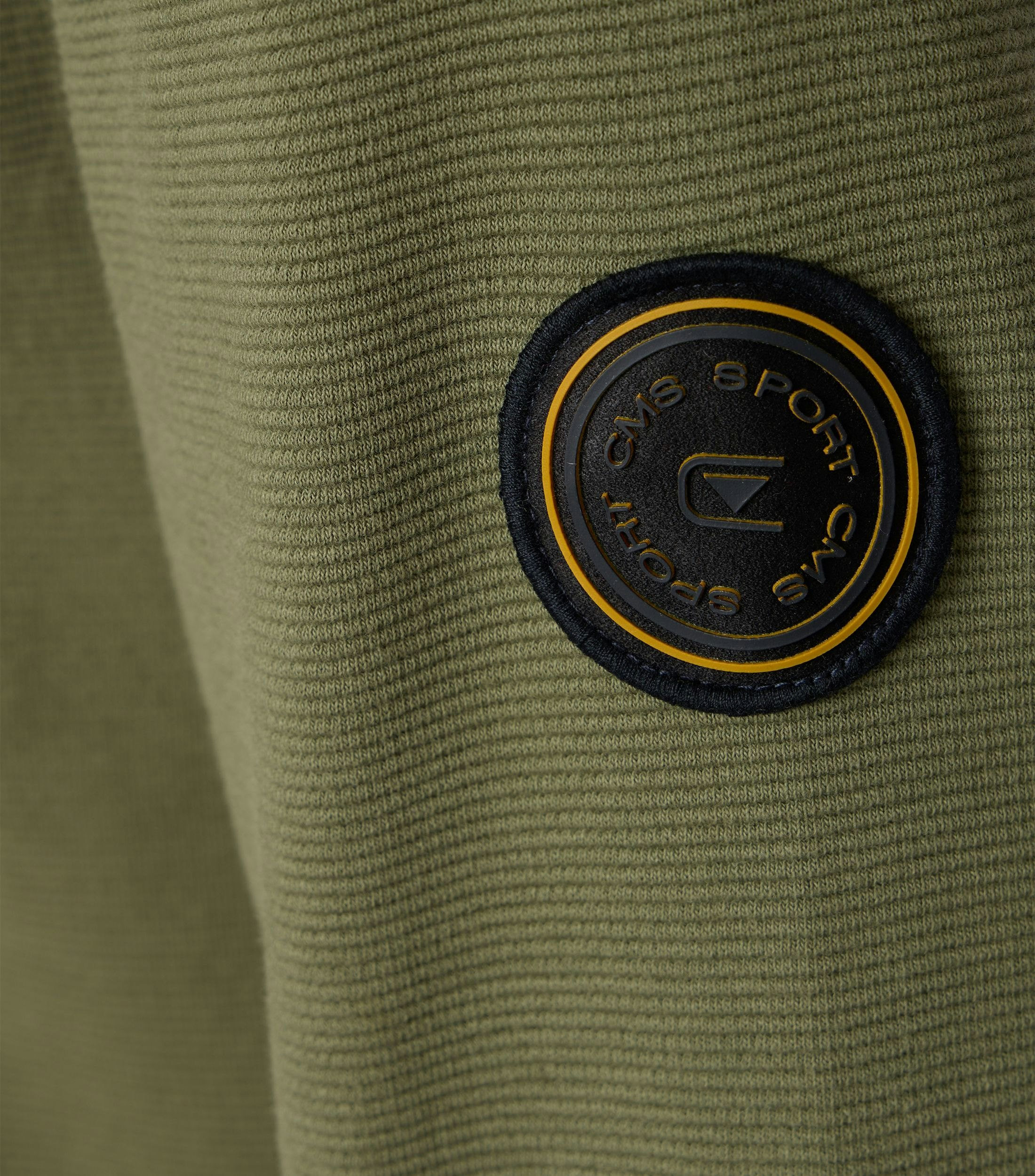 Das Model trägt ein Sweatshirt im uni Muster in der Farbe Olive