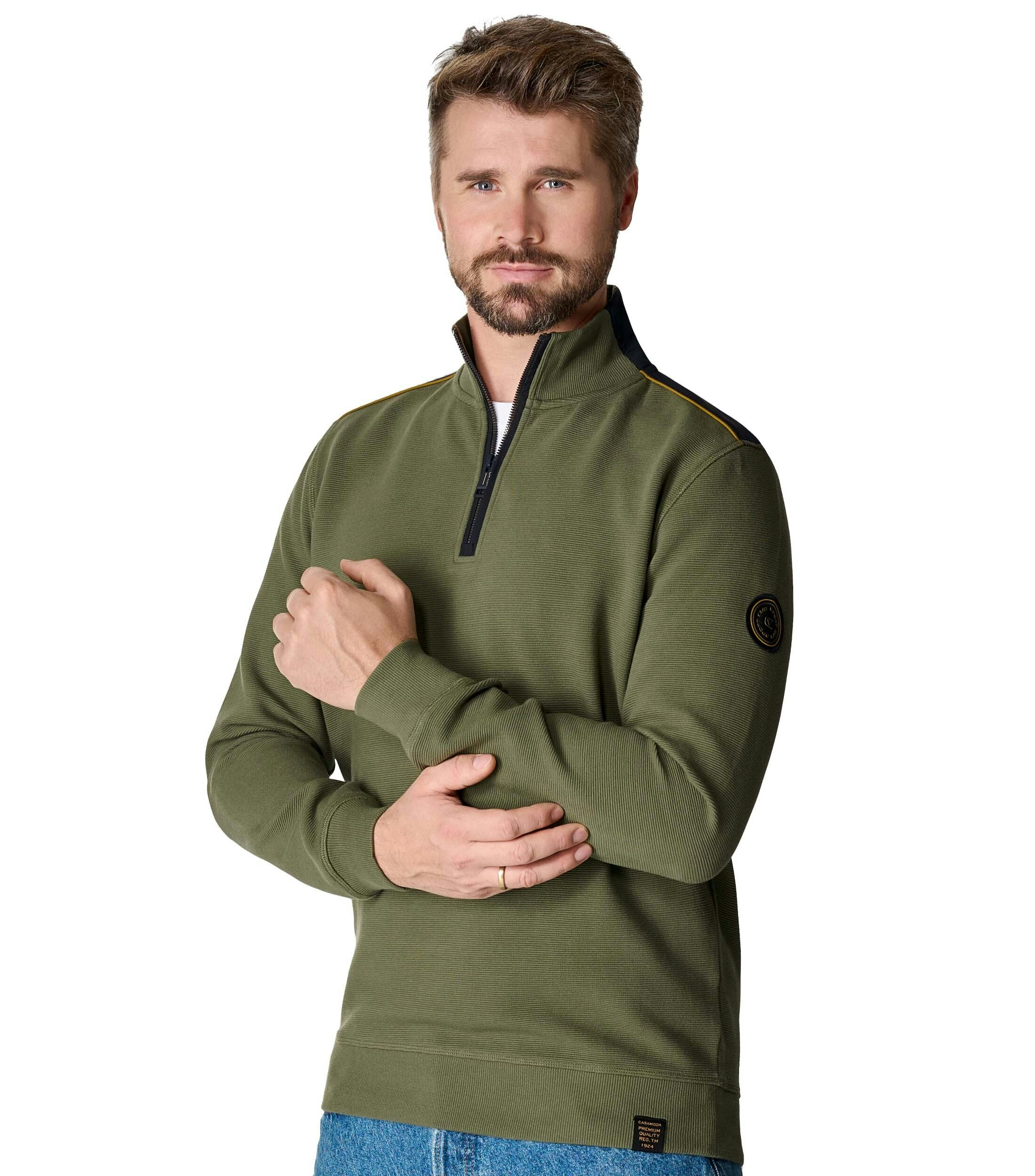 Das Model trägt ein Sweatshirt im uni Muster in der Farbe Olive