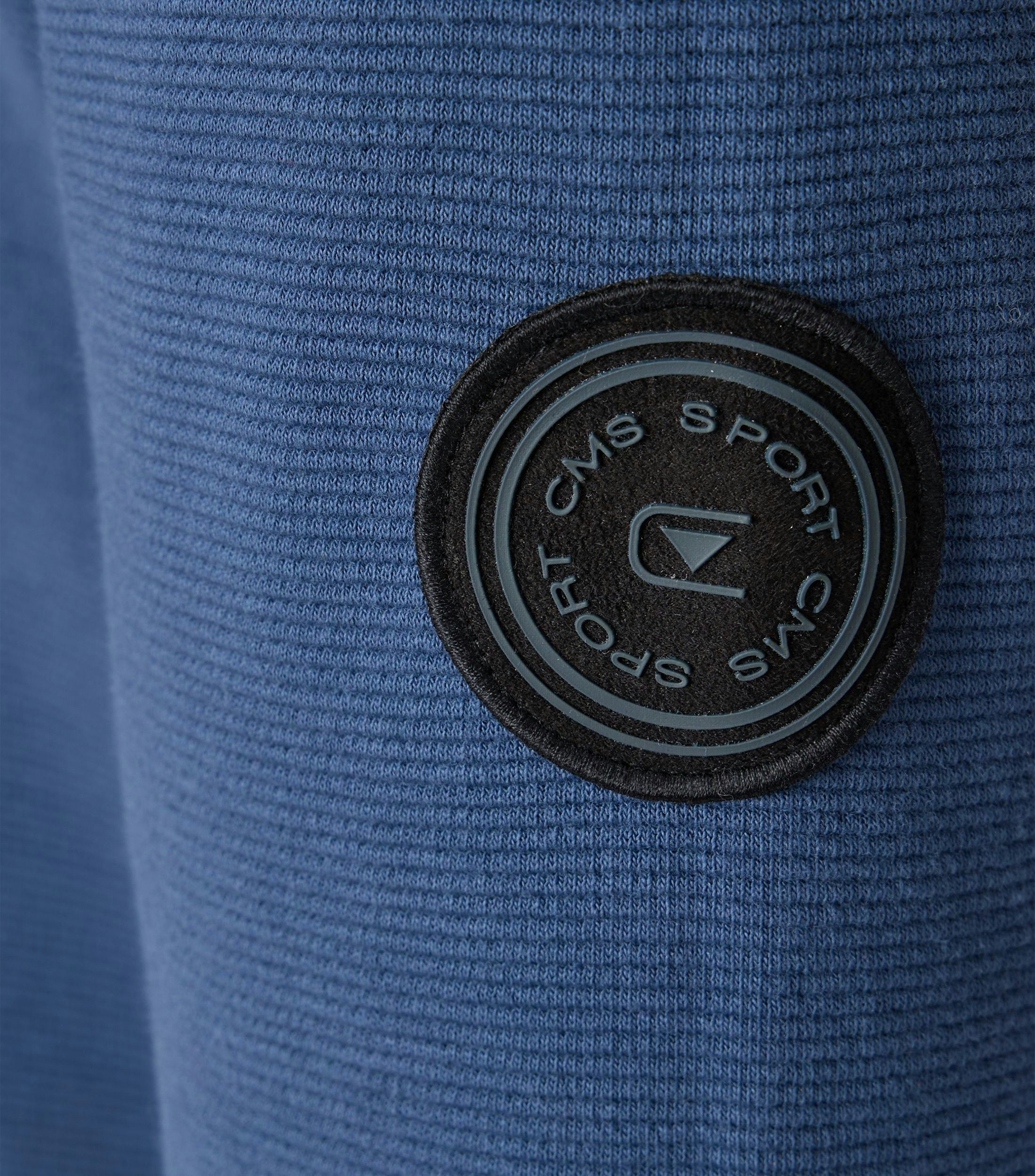 Das Model trägt ein Sweatshirt im uni Muster in der Farbe mittleres Dunkelblau