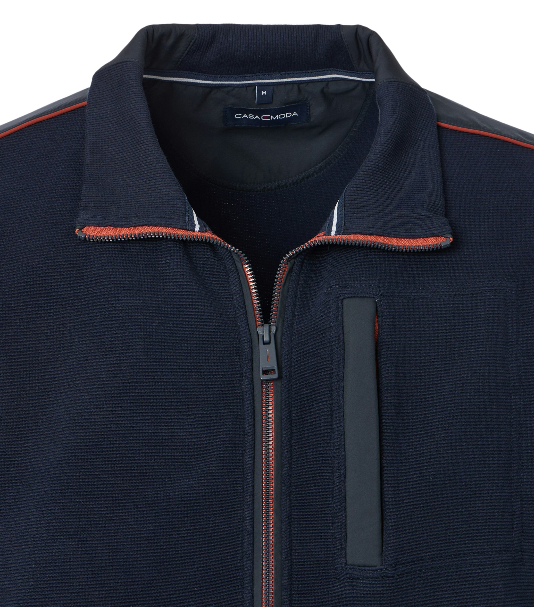 Das Model trägt eine Sweatjacke im uni Muster in der Farbe Blau