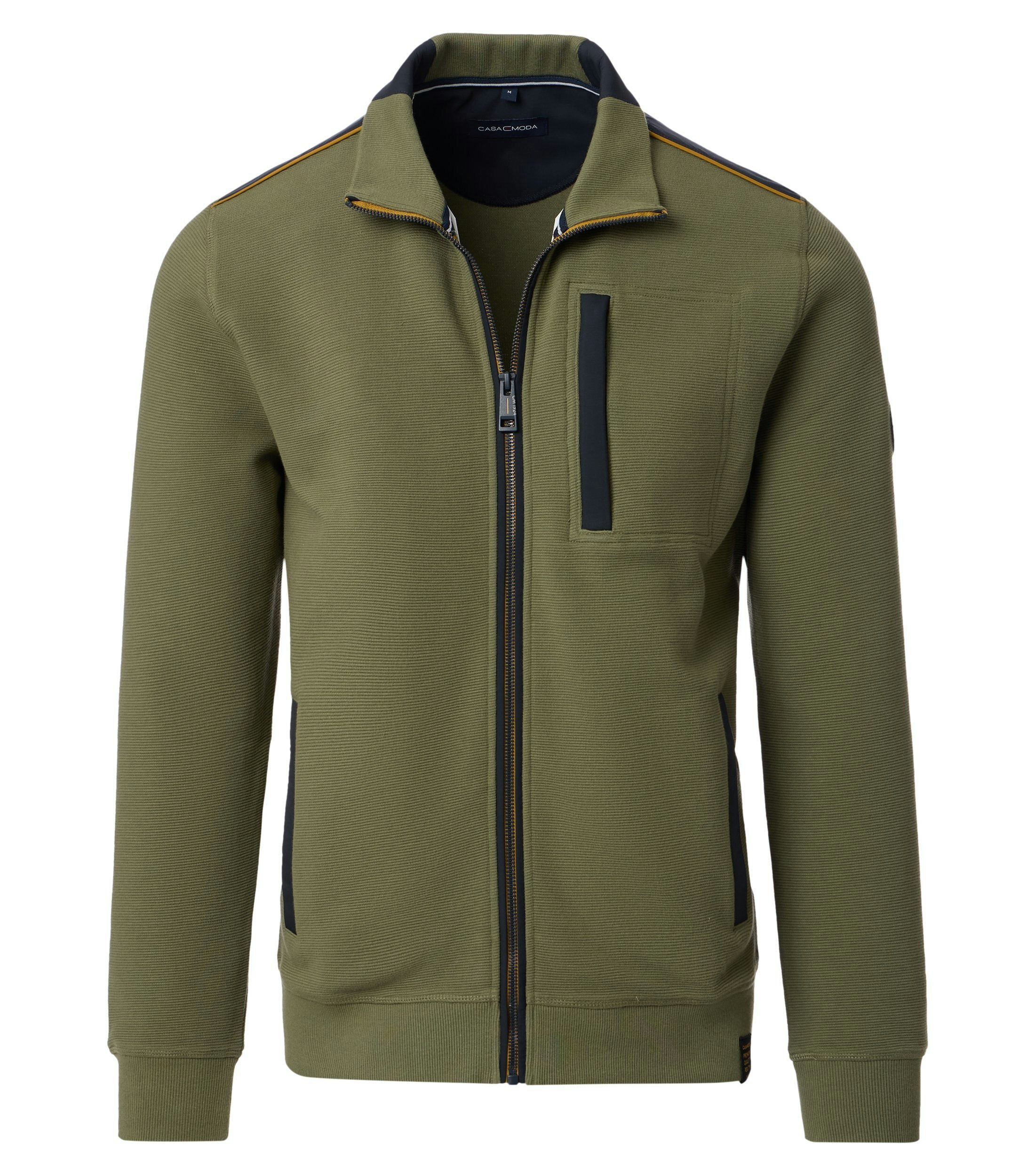 Das Model trägt eine Sweatjacke im uni Muster in der Farbe Grün