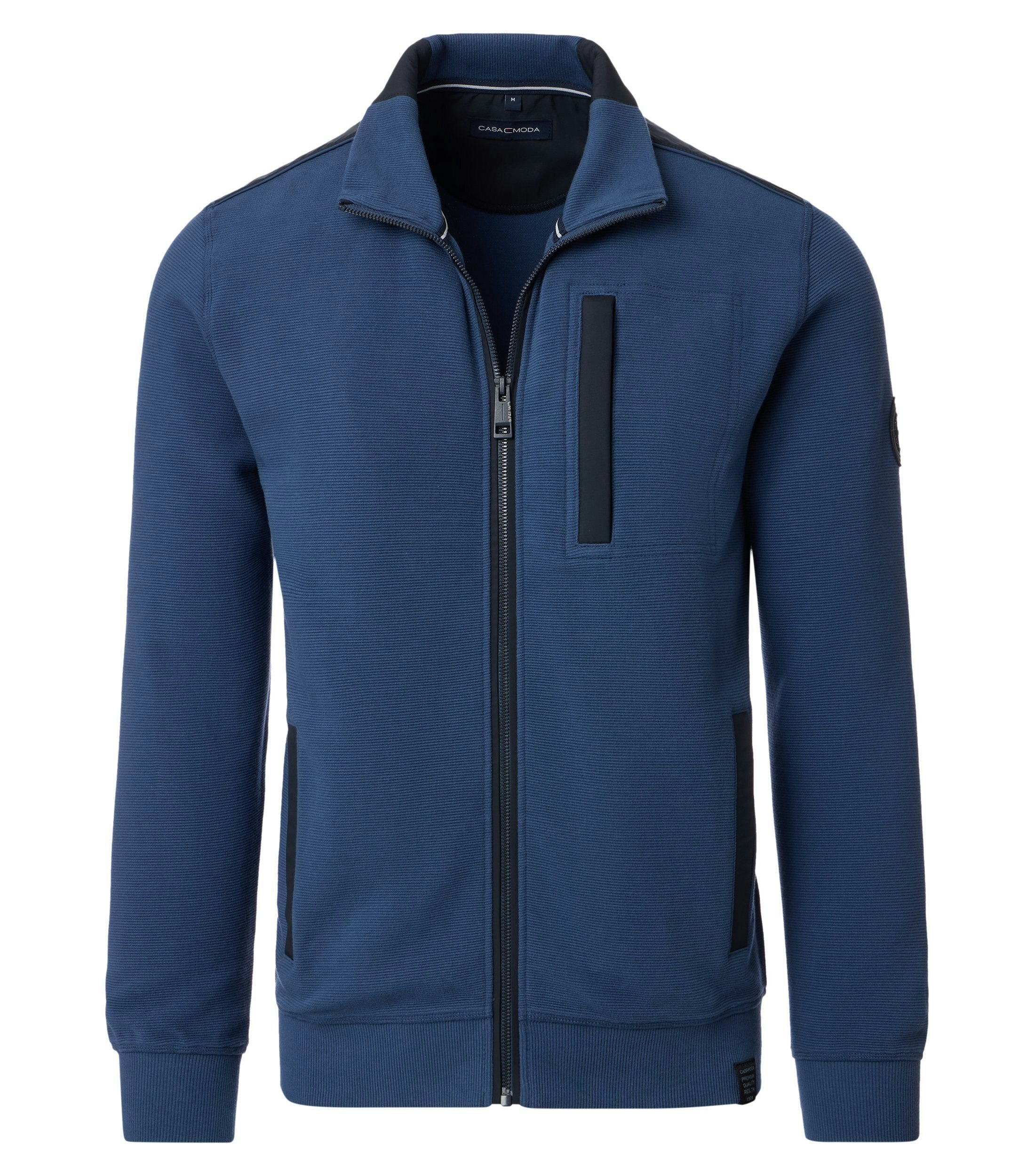 Das Model trägt eine Sweatjacke im uni Muster in der Farbe mittleres Dunkelblau