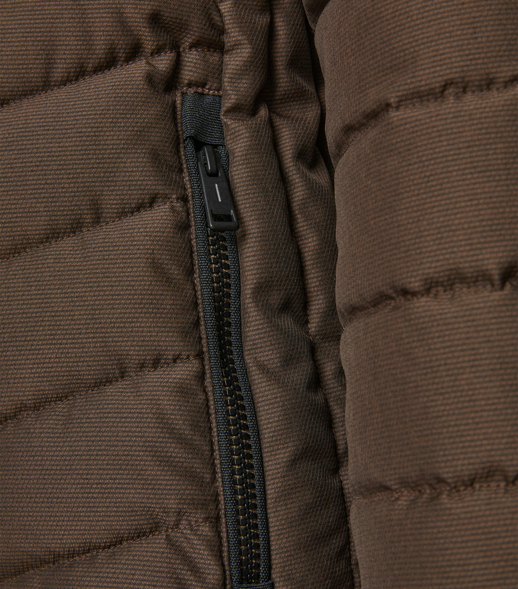 Das Model trägt eine Jacke im uni Muster in der Farbe Kastanienbraun