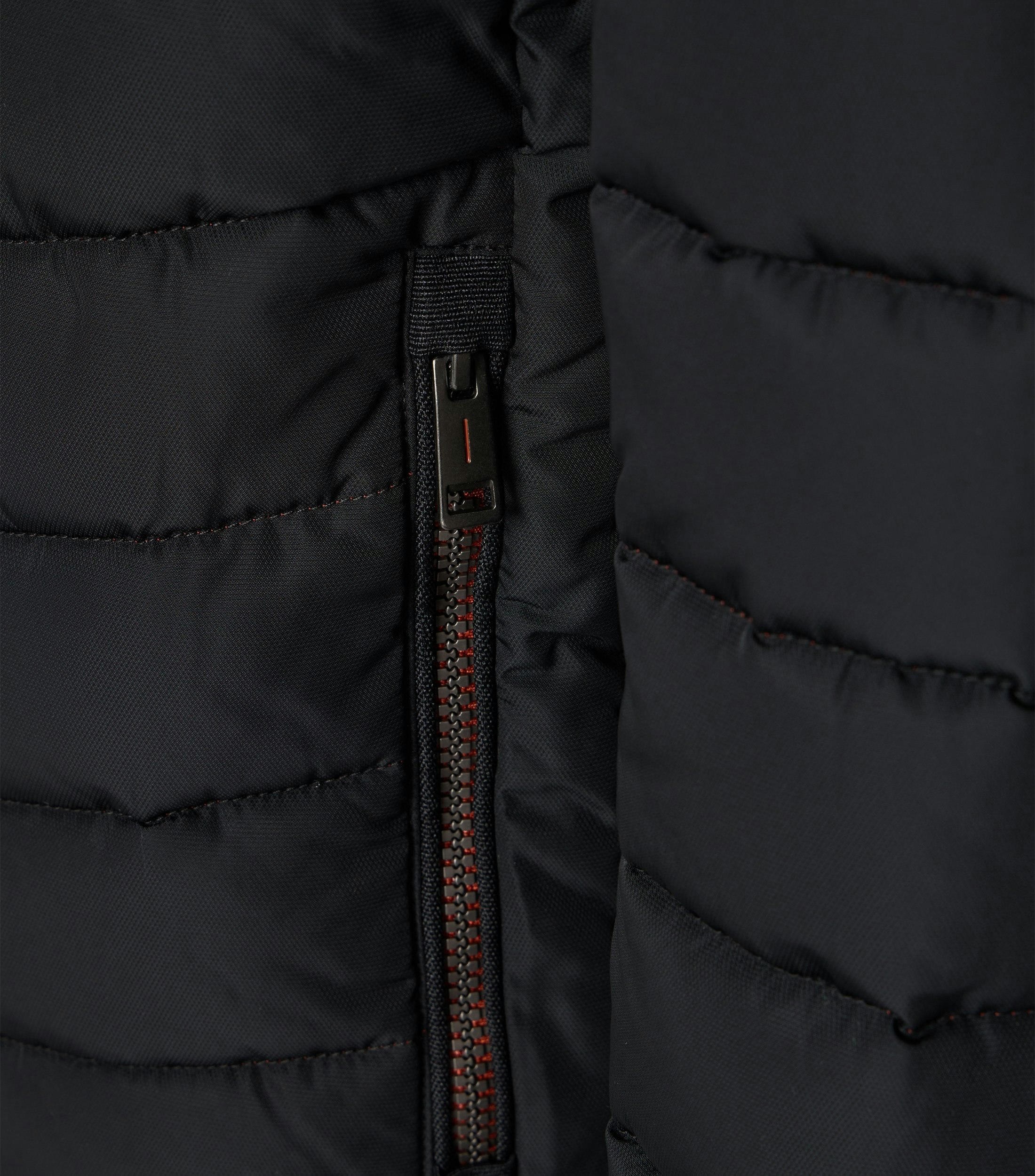 Das Model trägt eine Jacke im uni Muster in der Farbe Schwarz