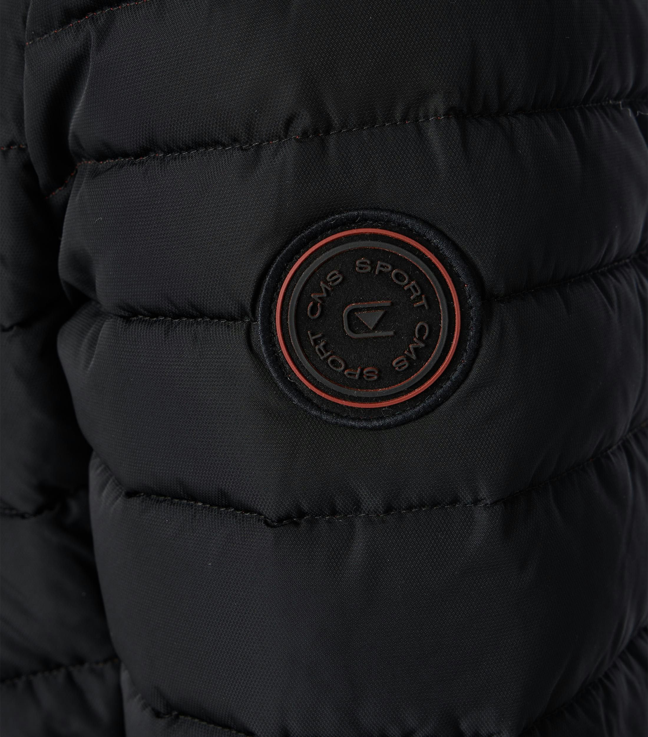 Das Model trägt eine Jacke im uni Muster in der Farbe Schwarz