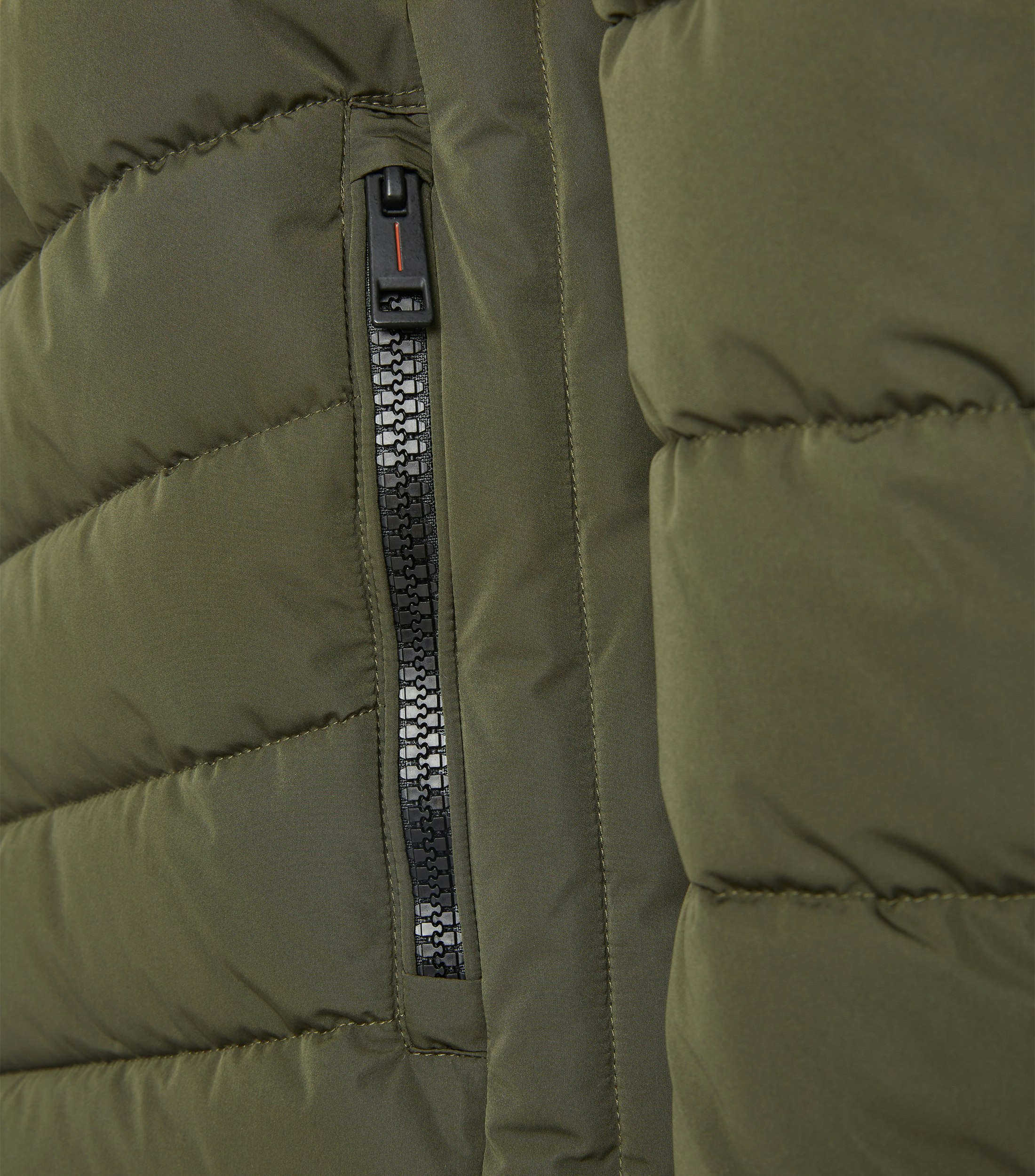 Das Model trägt eine Jacke im uni Muster in der Farbe Grün