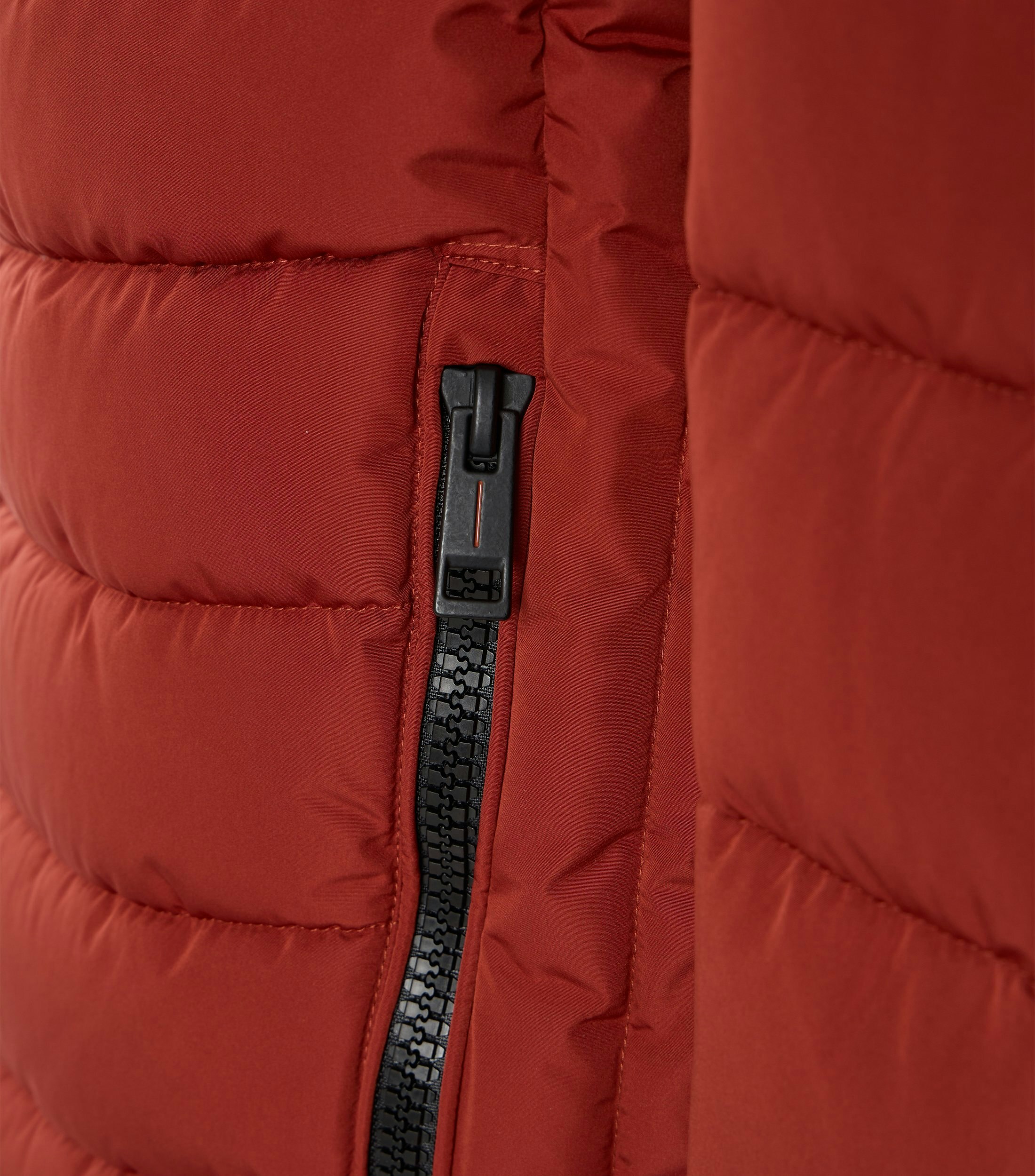 Das Model trägt eine Jacke im uni Muster in der Farbe Rot