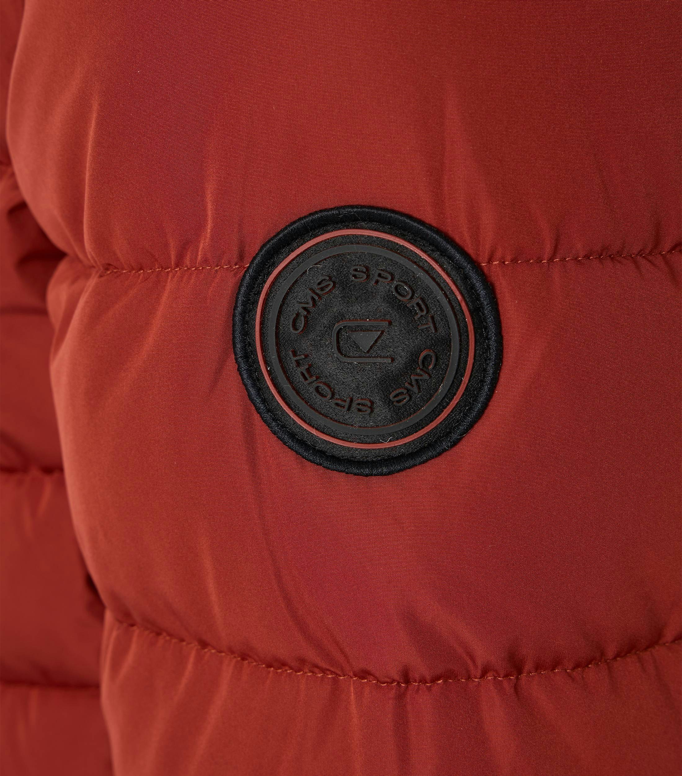 Das Model trägt eine Jacke im uni Muster in der Farbe Rot