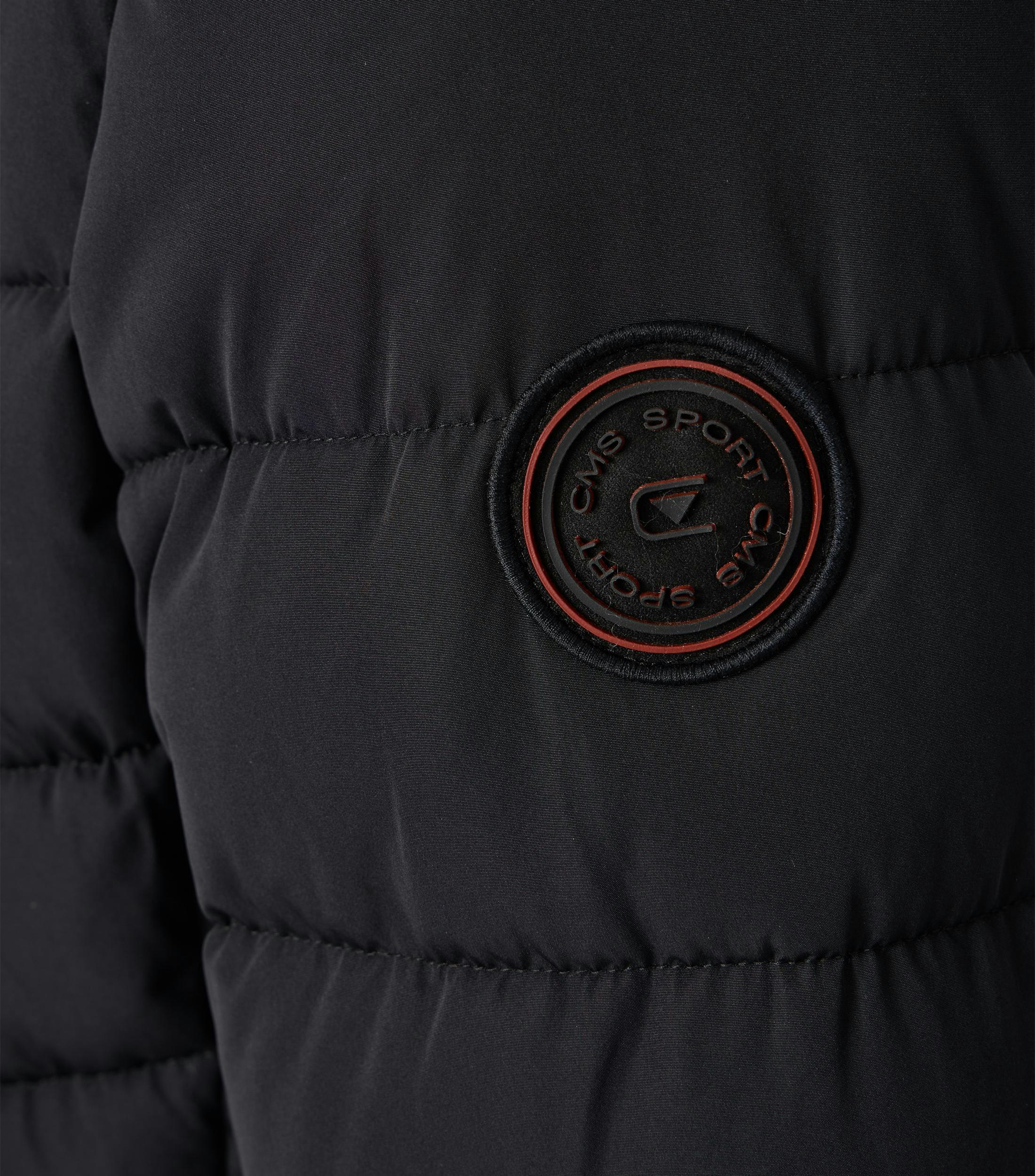 Das Model trägt eine Jacke im uni Muster in der Farbe Schwarz