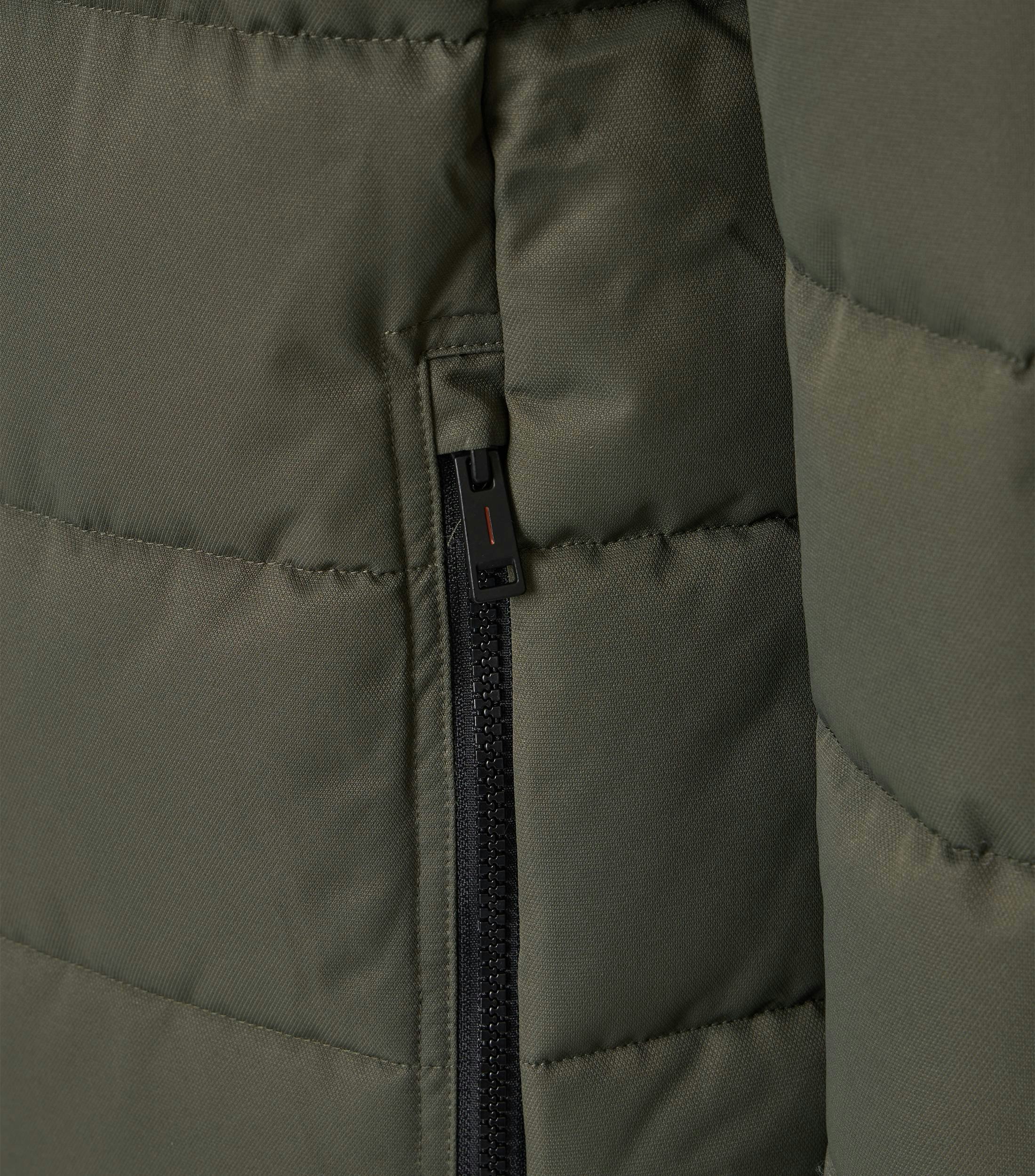 Das Model trägt eine Jacke im uni Muster in der Farbe Grün