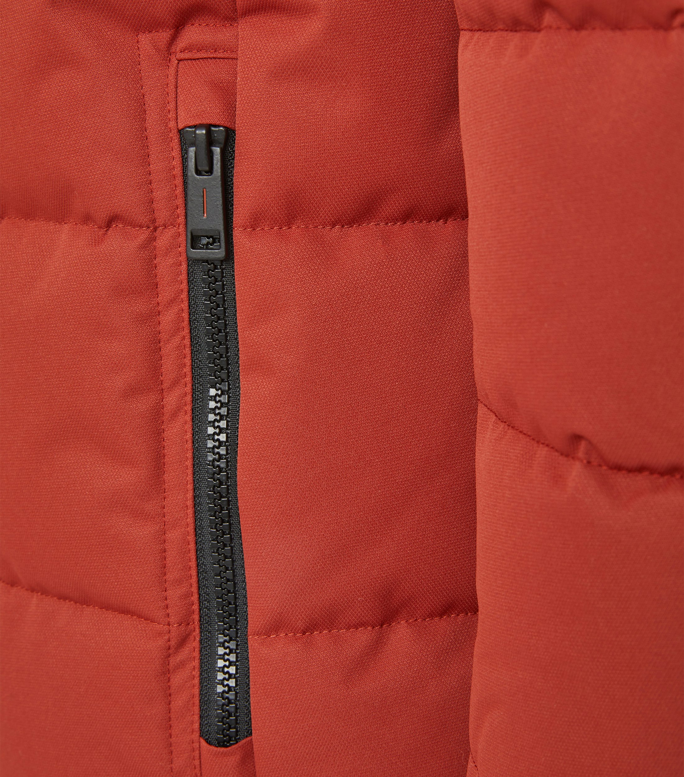 Das Model trägt eine Jacke im uni Muster in der Farbe Rot