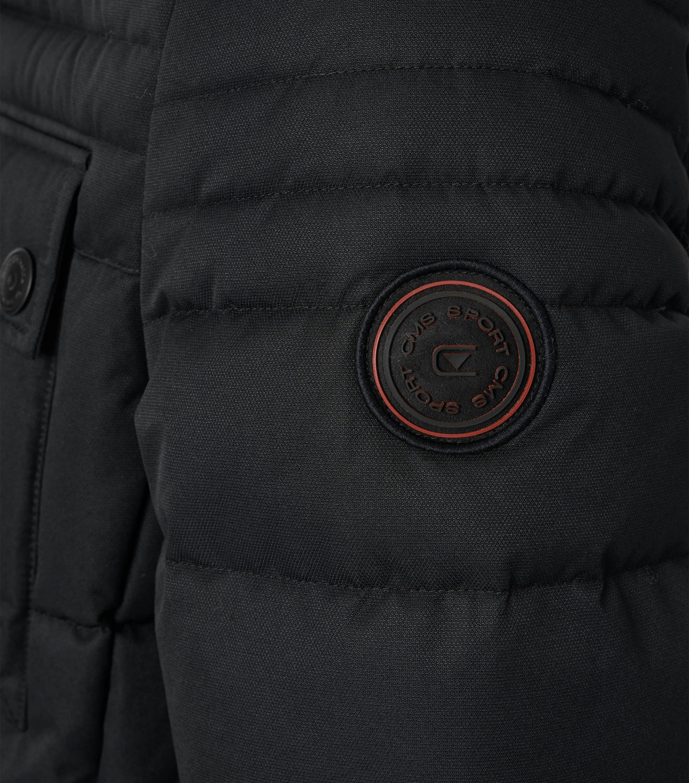 Das Model trägt eine Jacke im uni Muster in der Farbe Schwarz