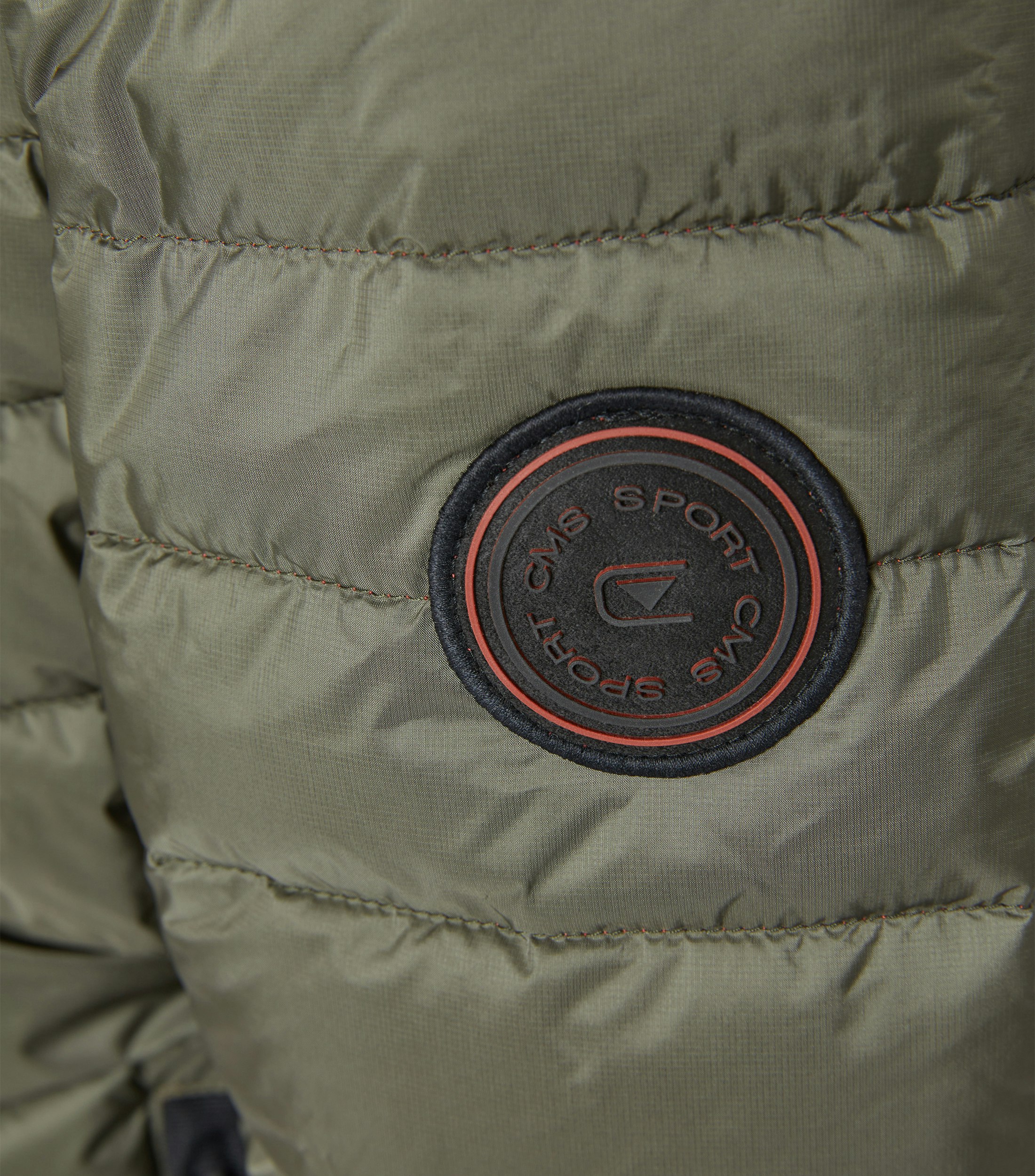 Das Model trägt eine Jacke im uni Muster in der Farbe Olive