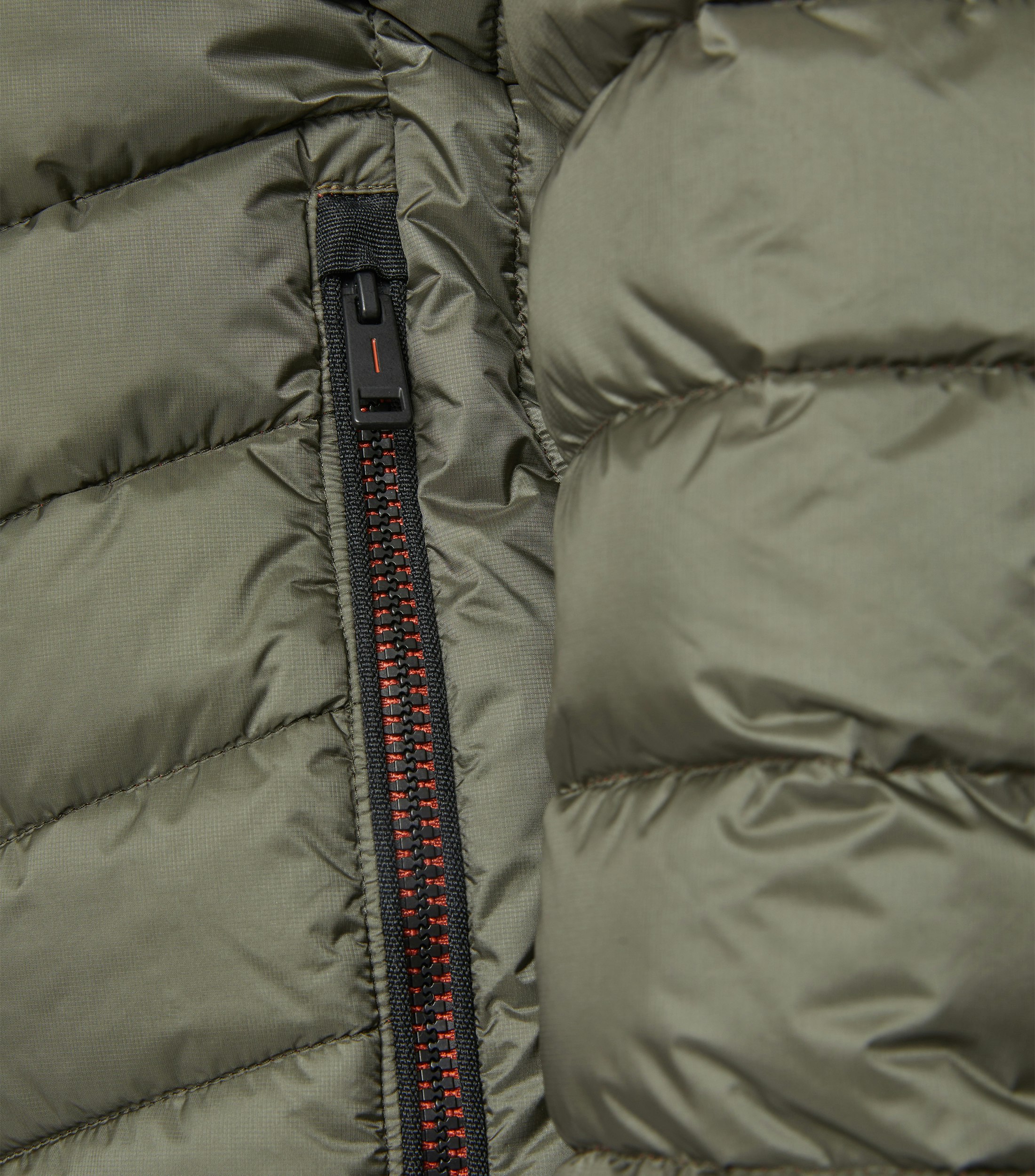 Das Model trägt eine Jacke im uni Muster in der Farbe Olive