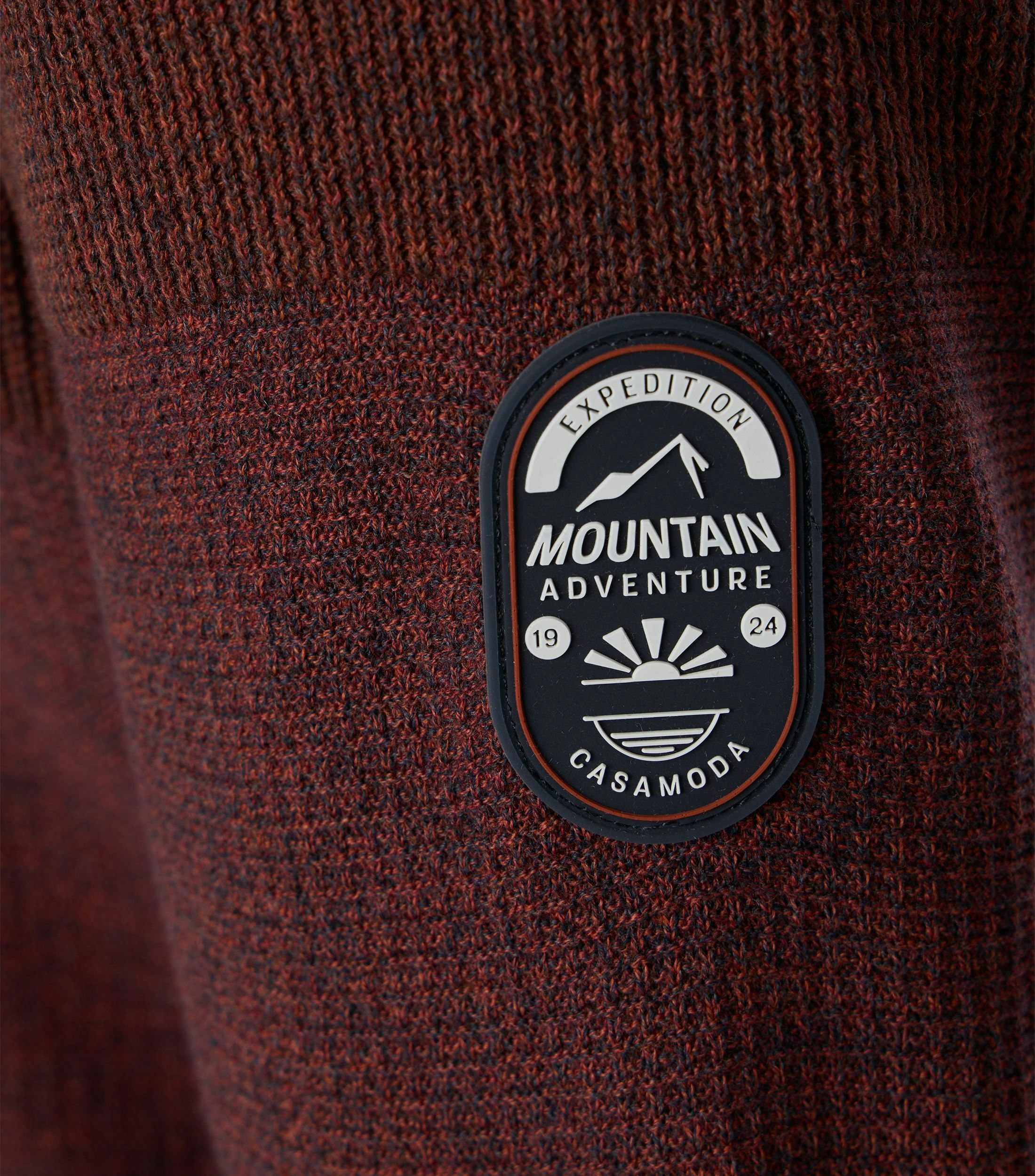 Das Model trägt ein Pullover im uni Muster in der Farbe Dunkelrot