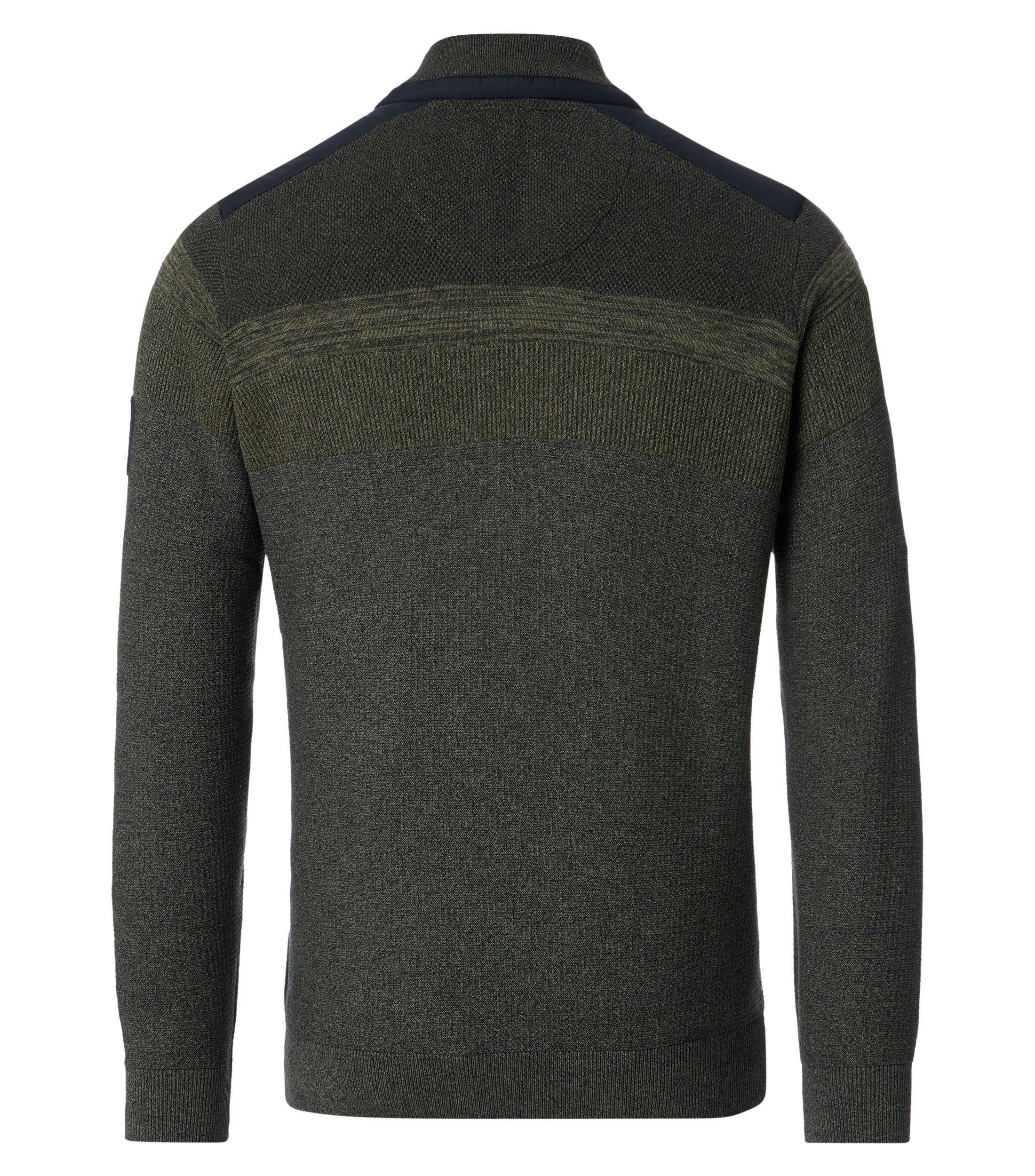 Das Model trägt ein Pullover im uni Muster in der Farbe Dunkelgrün