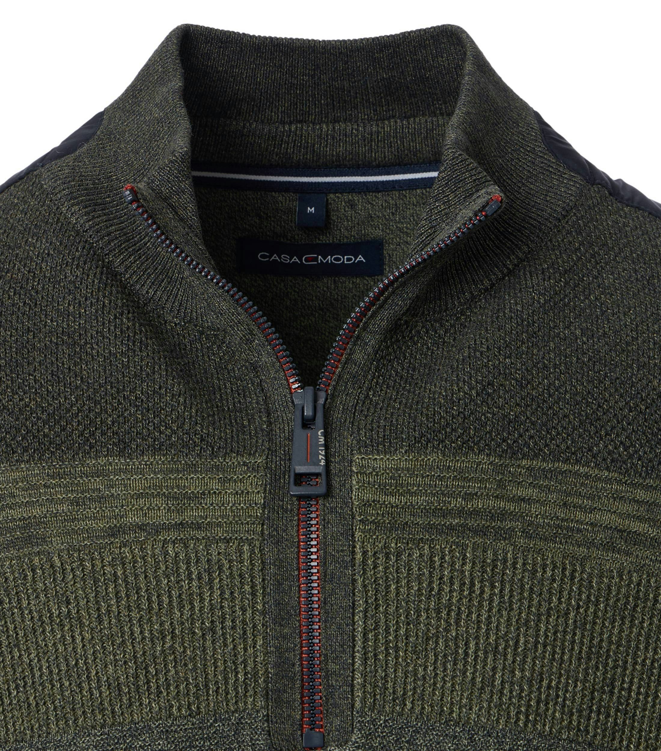 Das Model trägt ein Pullover im uni Muster in der Farbe Dunkelgrün