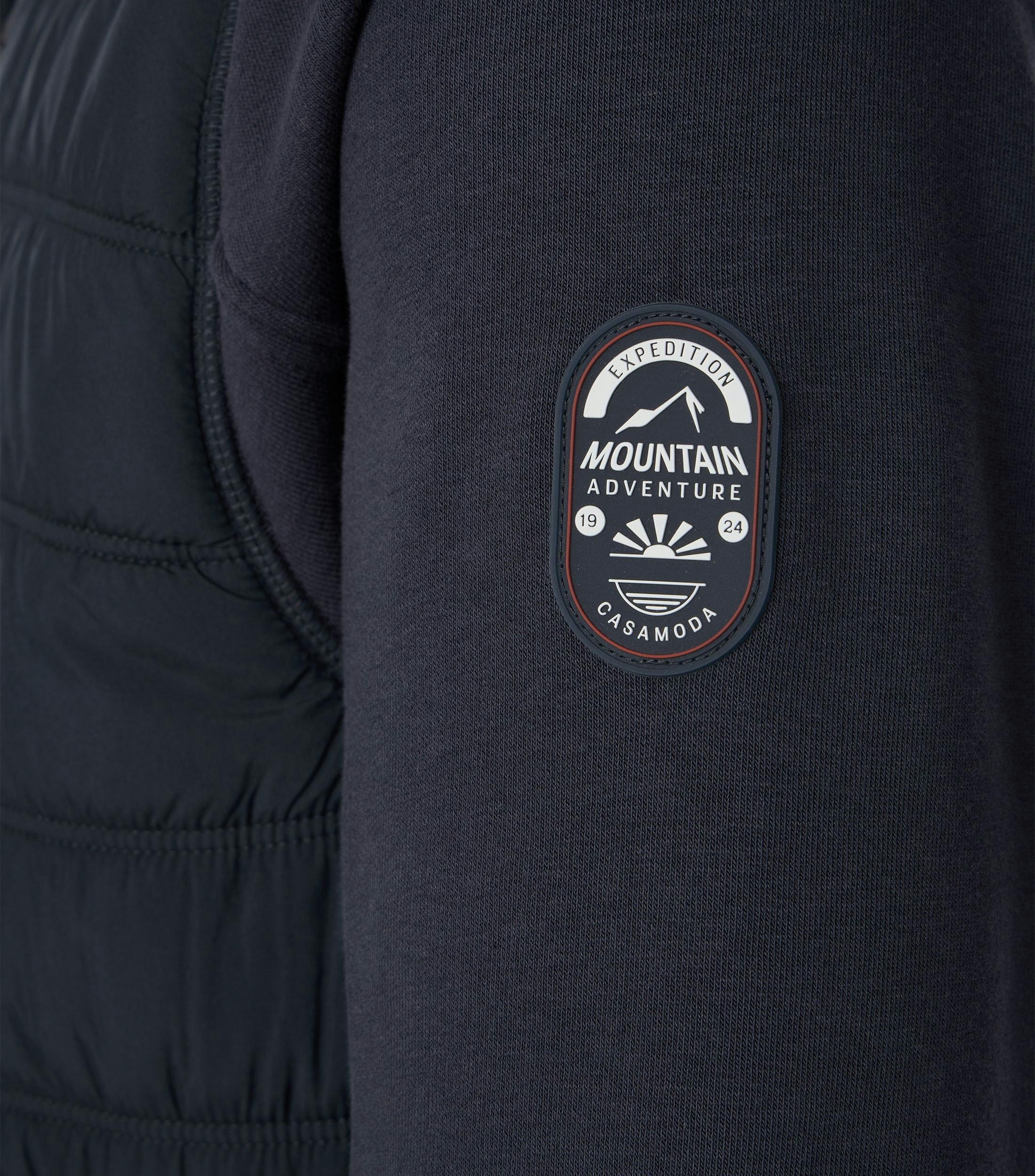 Das Model trägt ein Sweatshirt im uni Muster in der Farbe Blau