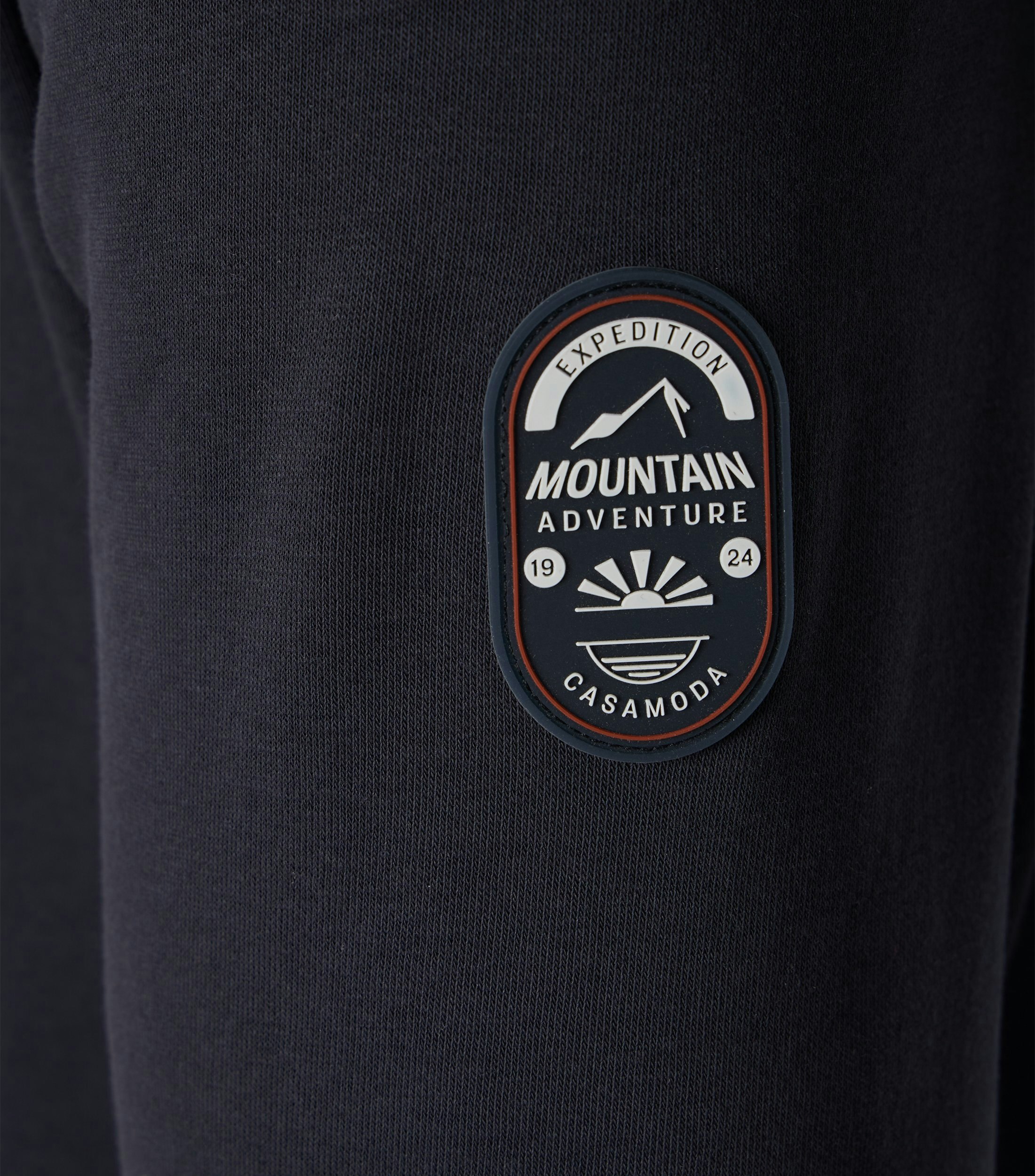 Das Model trägt ein Sweatshirt im uni Muster in der Farbe Dunkelblau