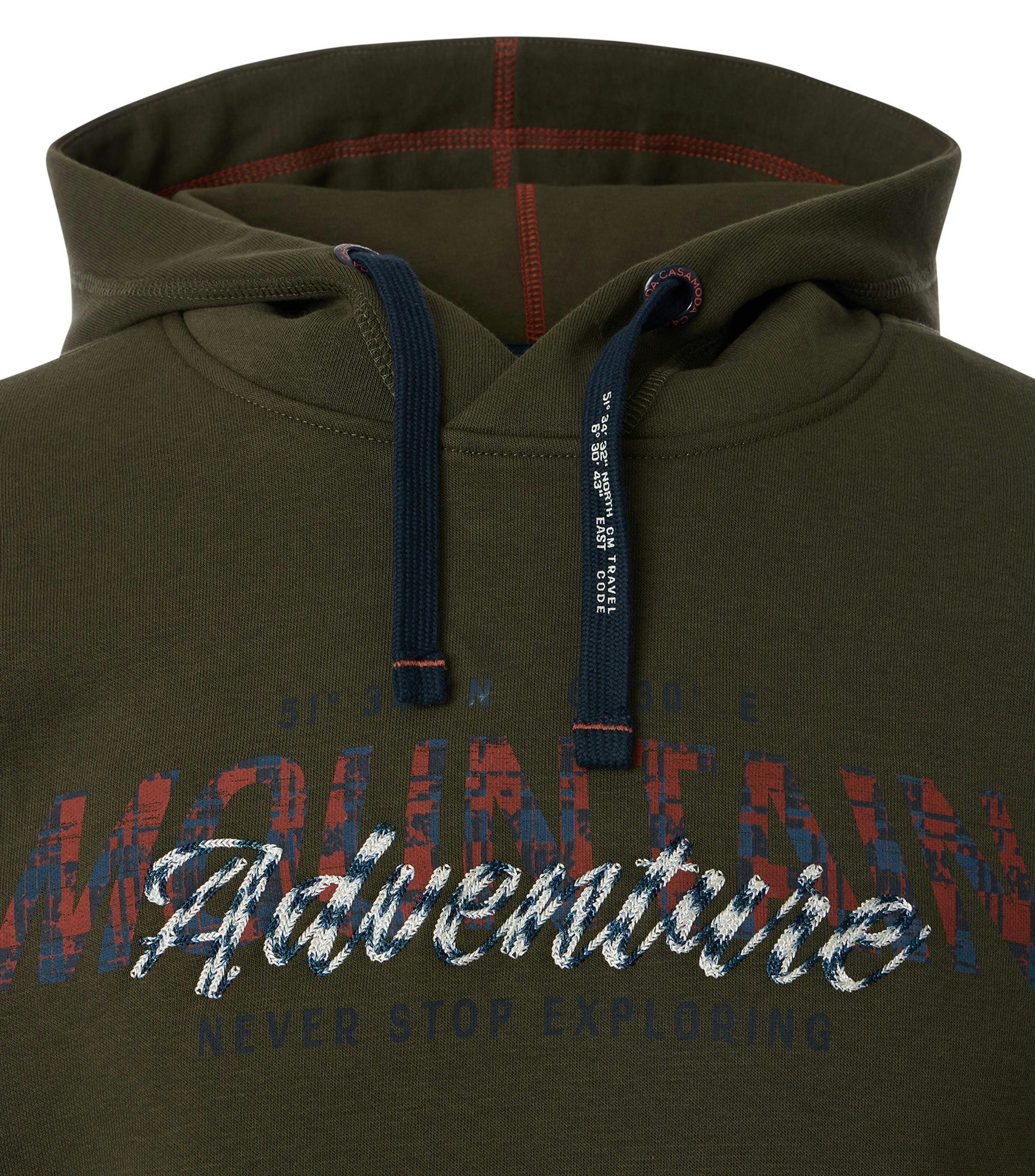 Das Model trägt ein Sweatshirt im uni Muster in der Farbe Dunkelgrün