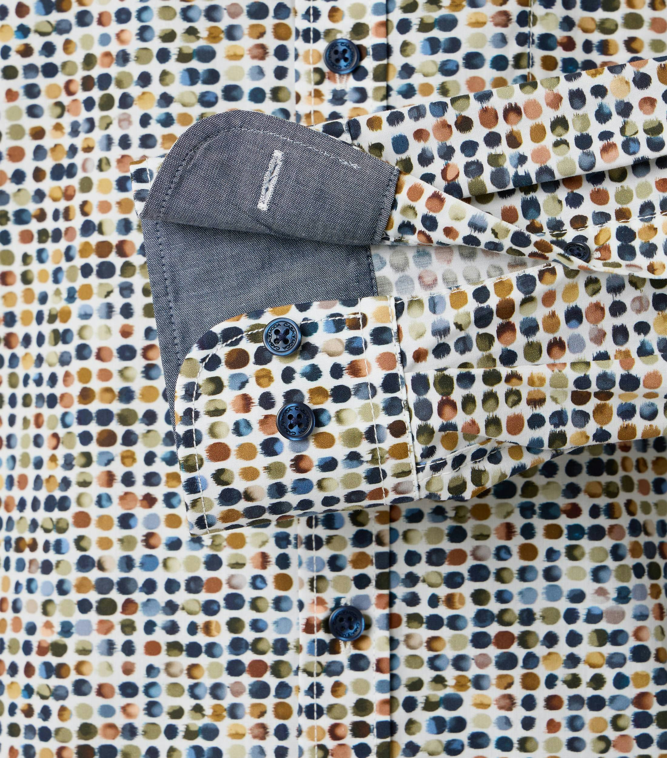 Das Model trägt ein Freizeithemd im Print Muster in der Farbe Grün