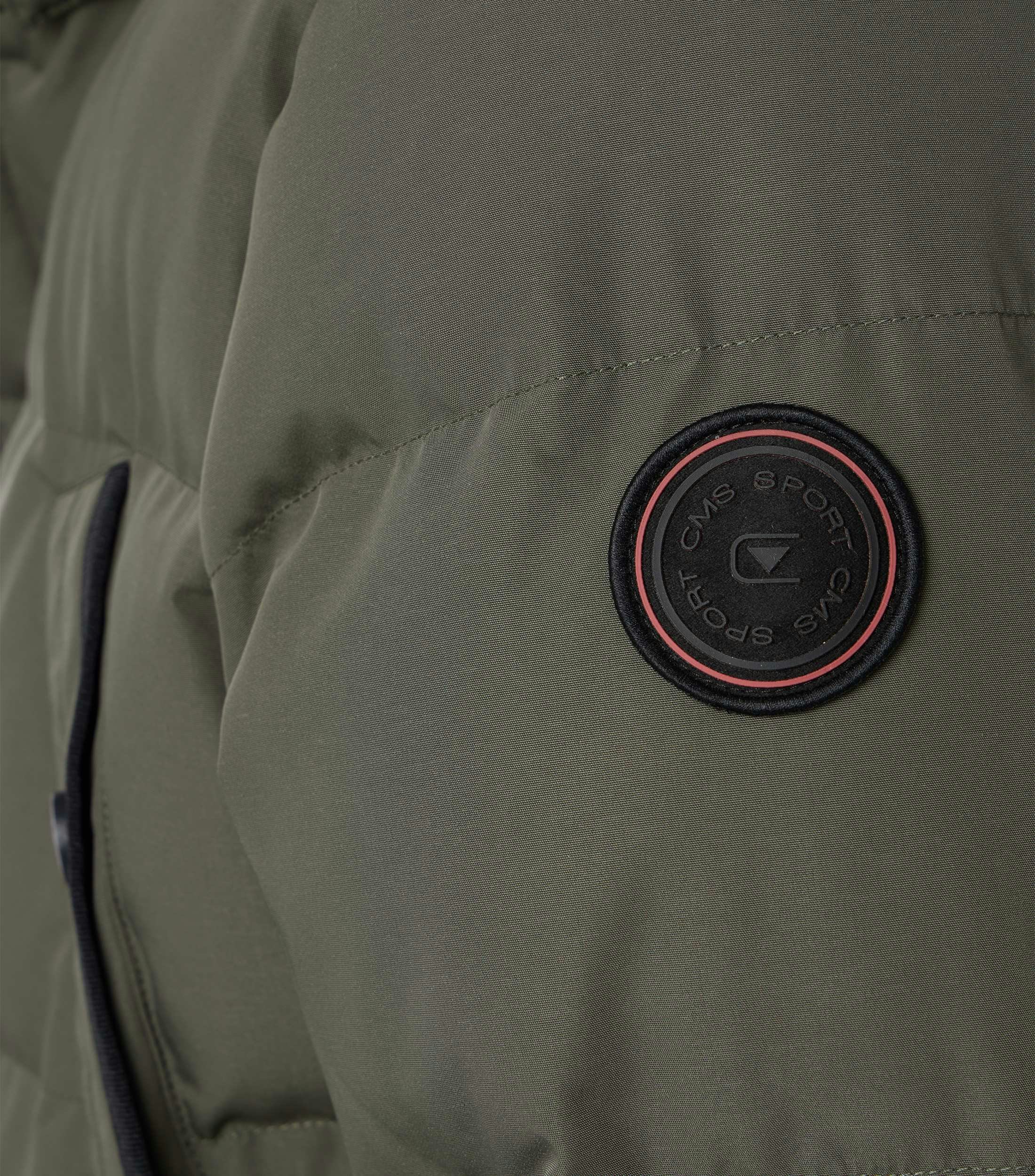 Das Model trägt eine Jacke im uni Muster in der Farbe Grün