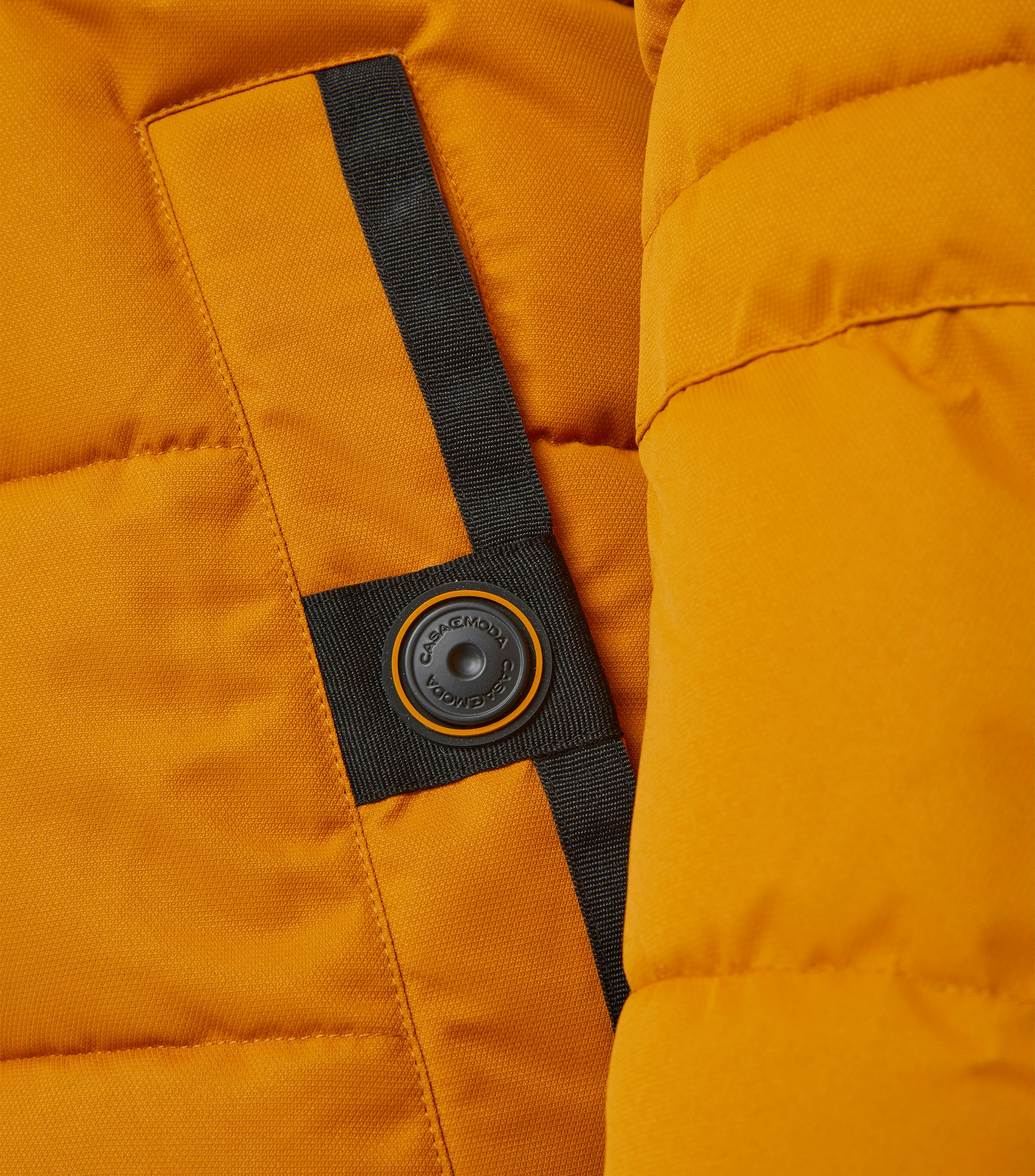 Das Model trägt eine Jacke im uni Muster in der Farbe Honiggelb