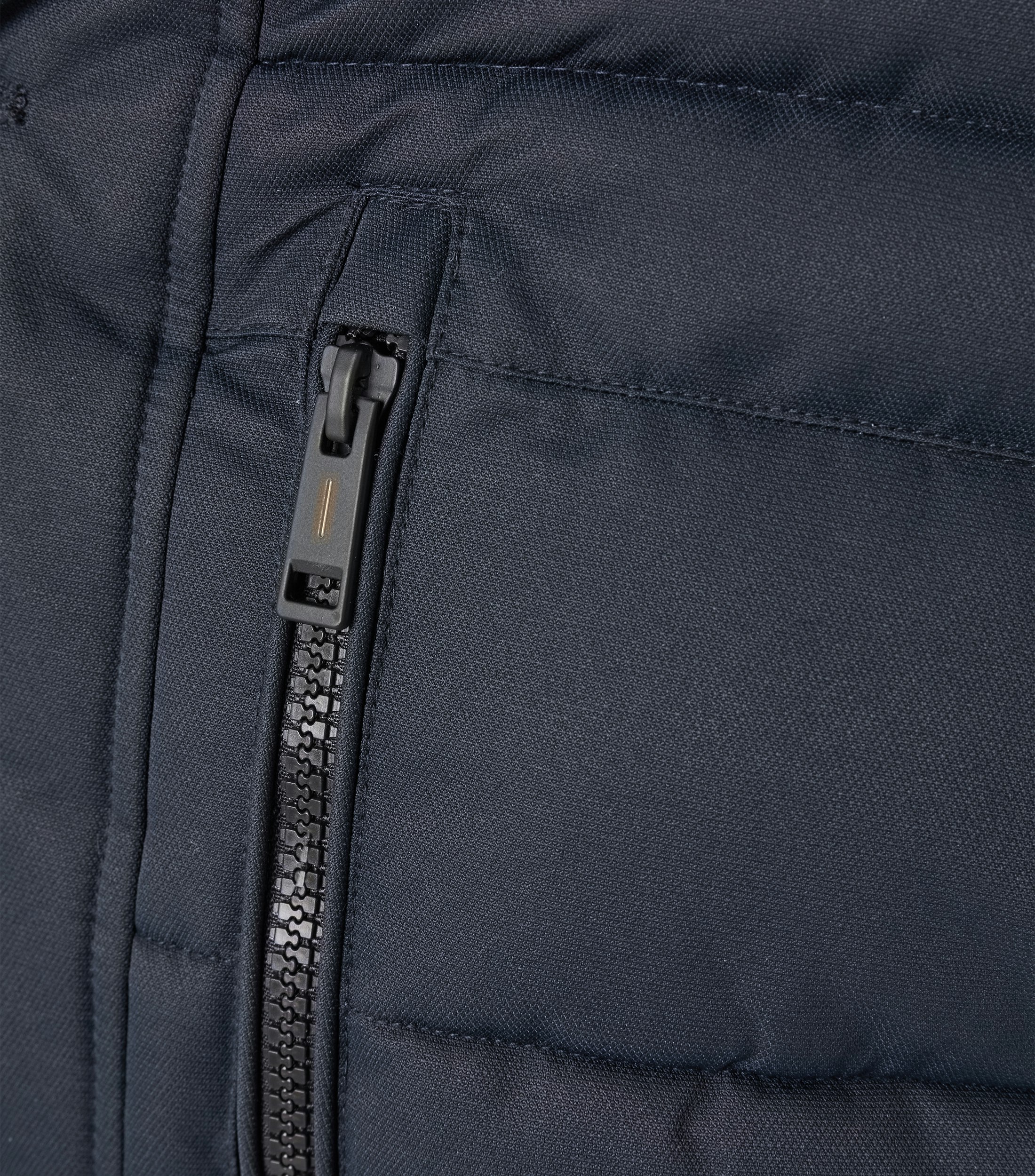 Das Model trägt eine Jacke im uni Muster in der Farbe Dunkelblau