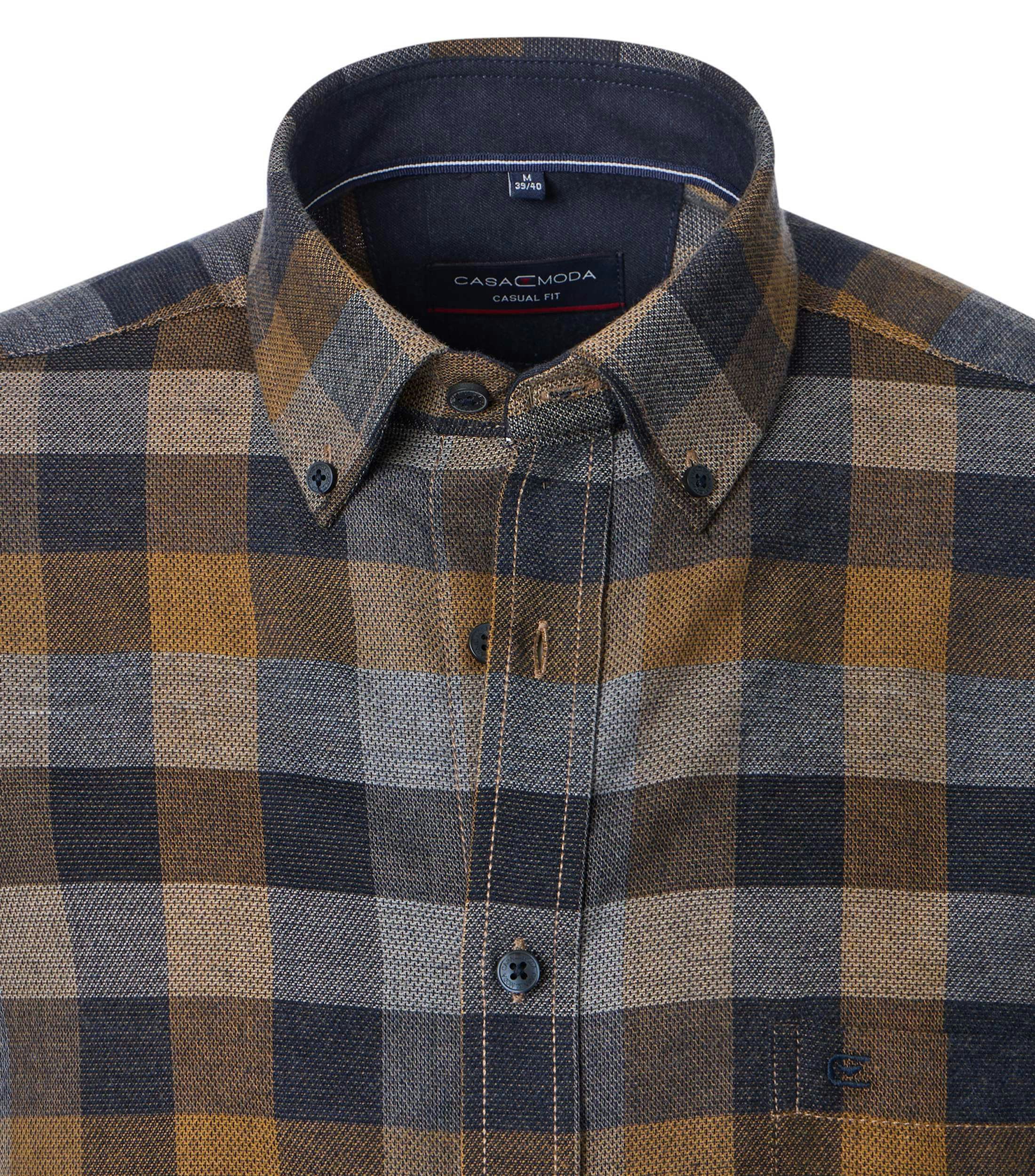 Das Model trägt ein Freizeithemd im kariert Muster in der Farbe Gelb