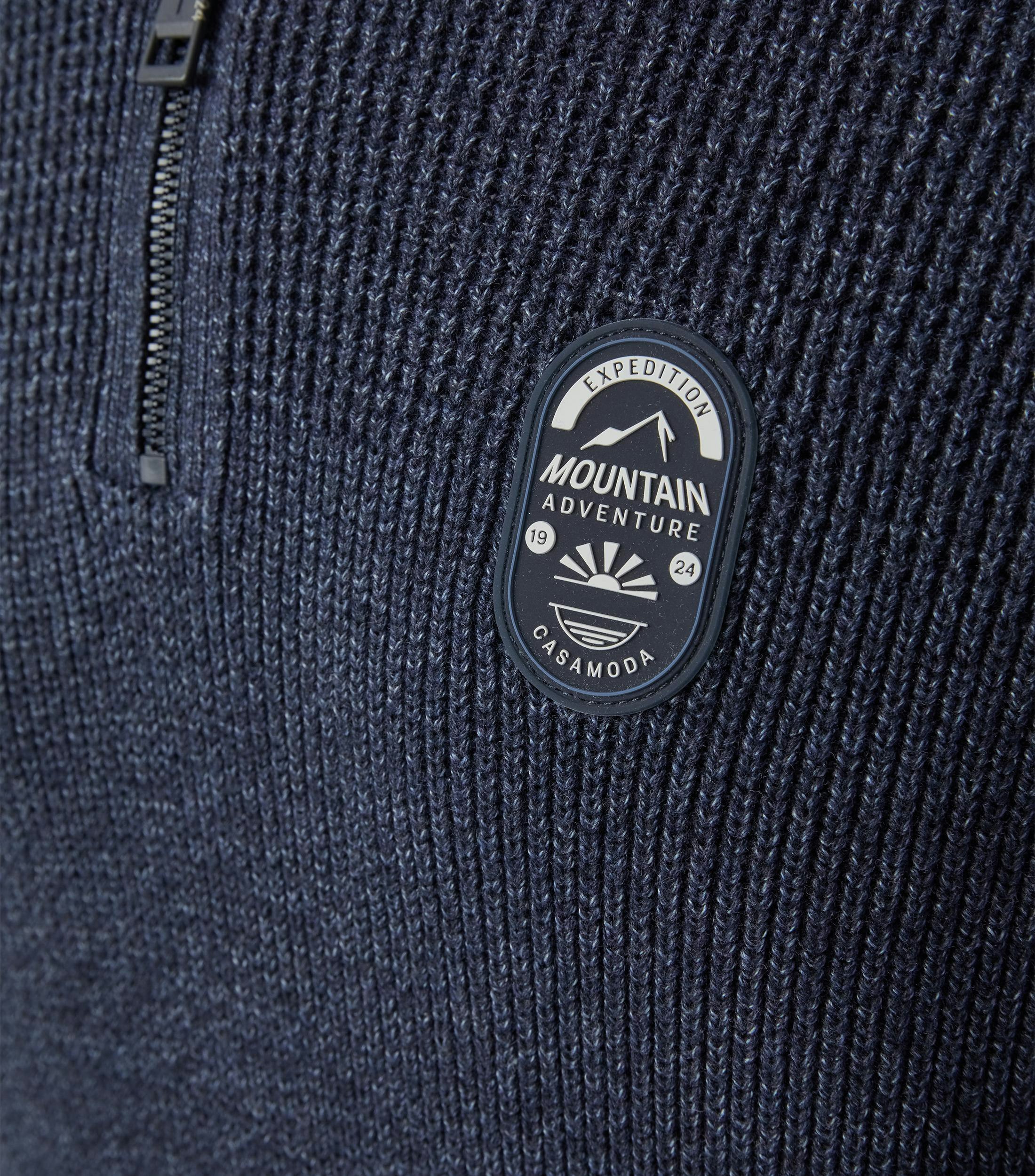 Das Model trägt ein Pullover im uni Muster in der Farbe Dunkelblau