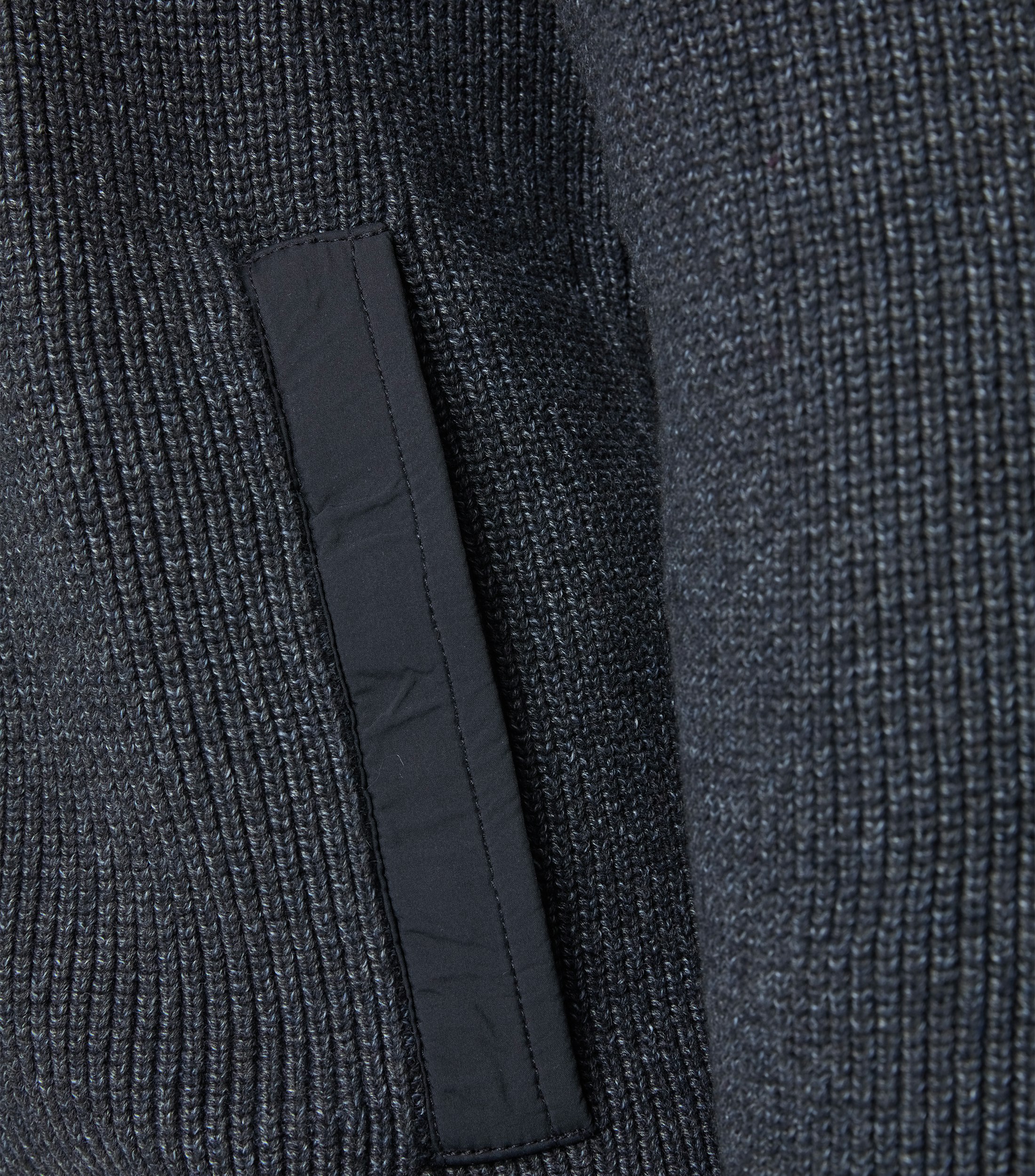 Das Model trägt eine Strickjacke im uni Muster in der Farbe Dunkelblau