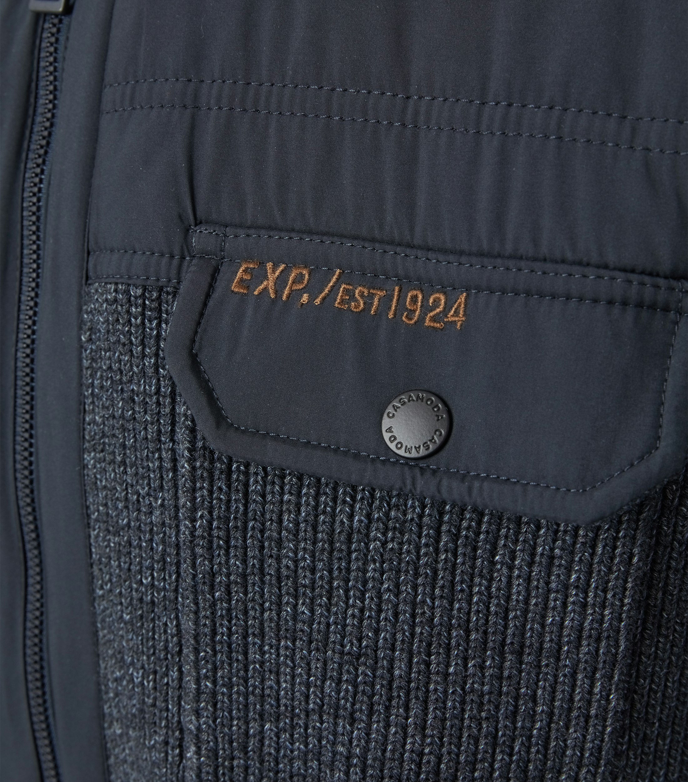 Das Model trägt eine Strickjacke im uni Muster in der Farbe Dunkelblau