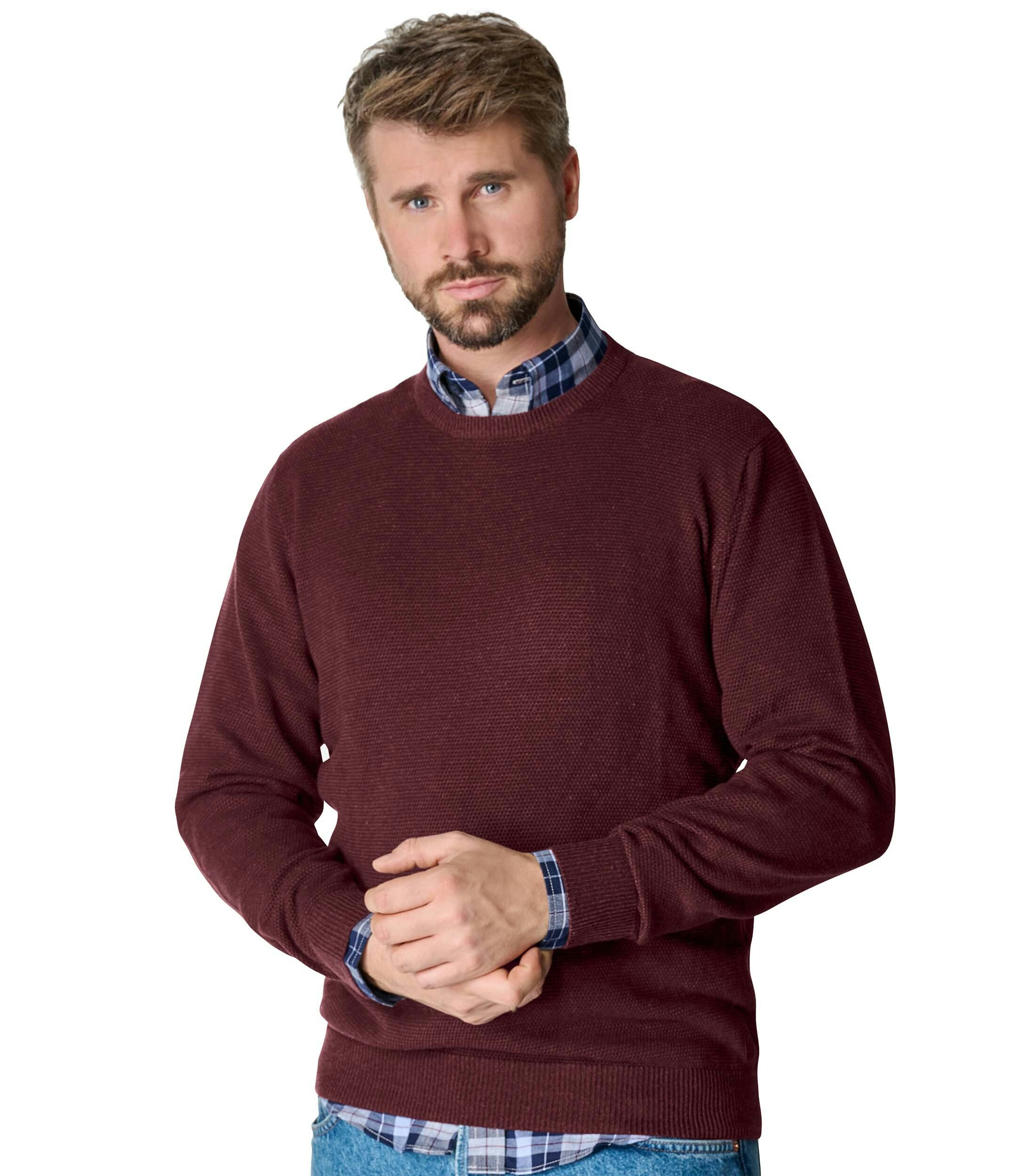 Das Model trägt ein Pullover im uni Muster in der Farbe Bordeauxrot