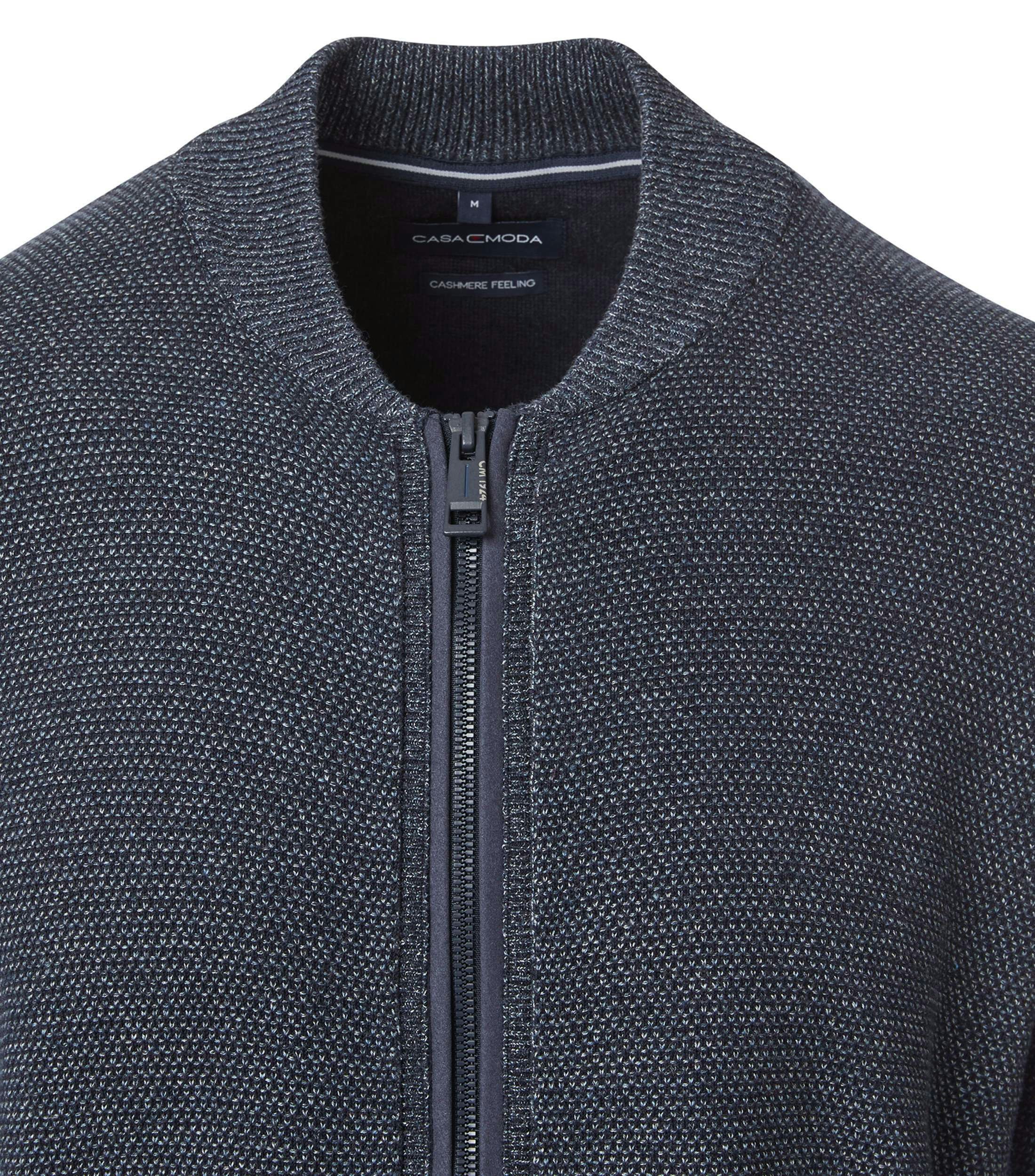 Das Model trägt eine Strickjacke im uni Muster in der Farbe Blau