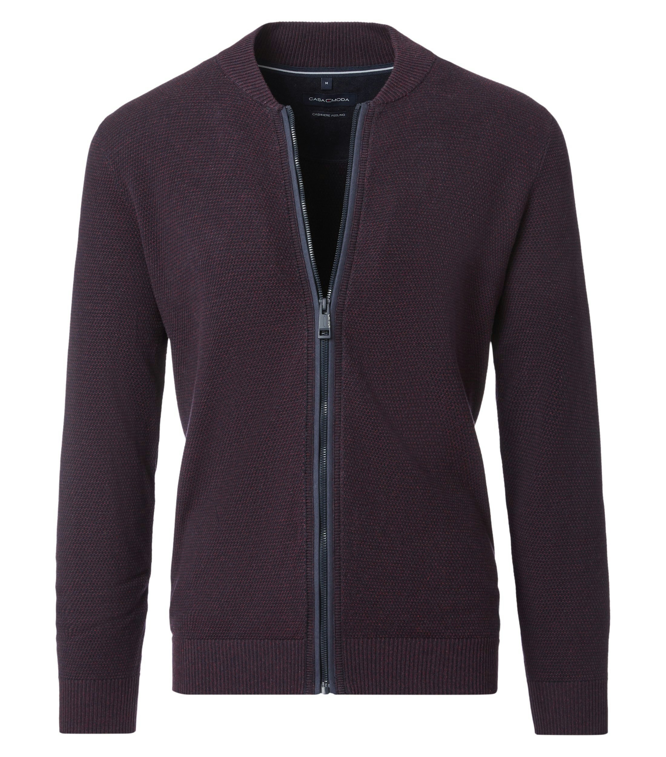 Das Model trägt eine Strickjacke im uni Muster in der Farbe Dunkelrot