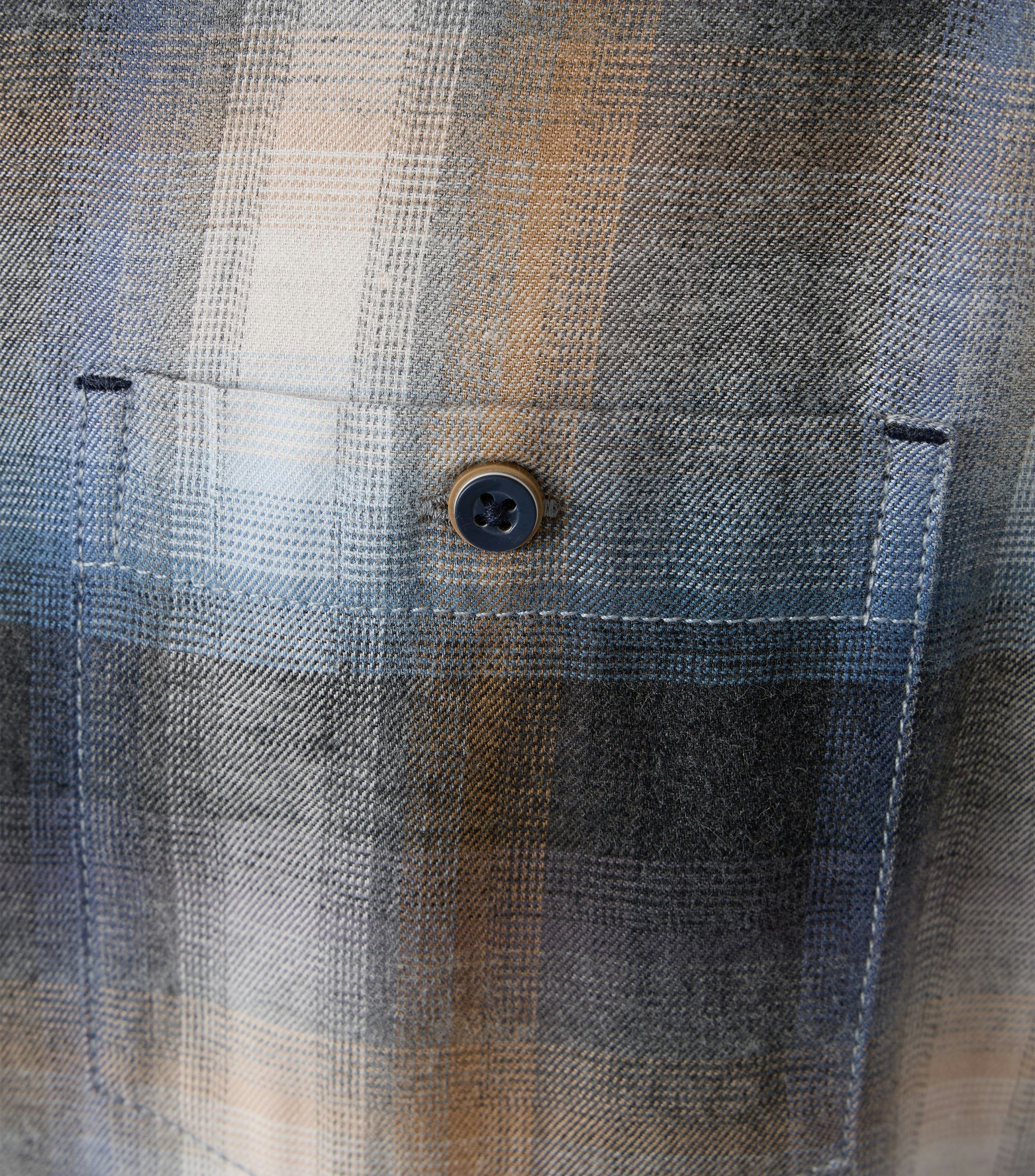 Das Model trägt ein Freizeithemd im kariert Muster in der Farbe Weißblau