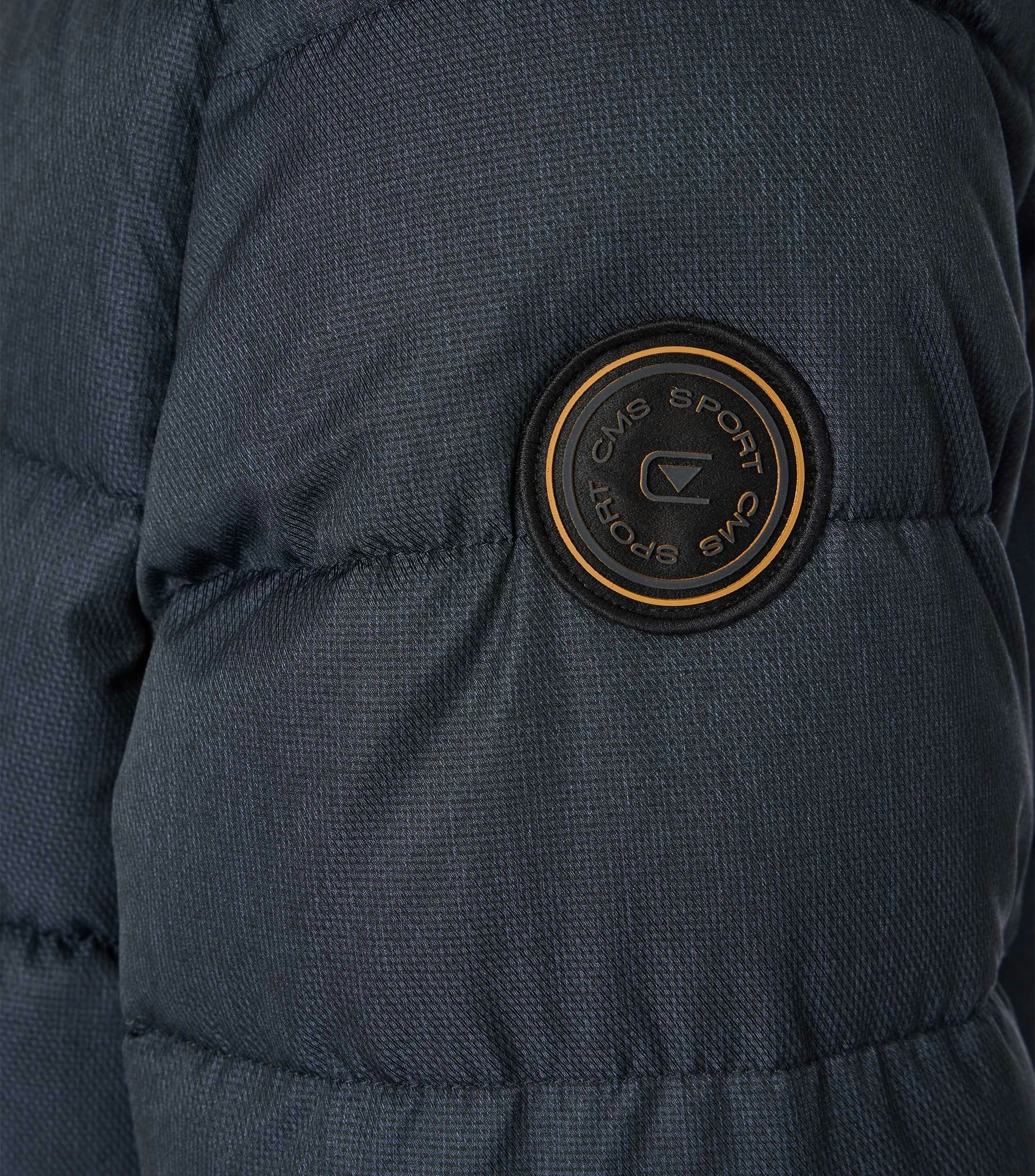 Das Model trägt eine Jacke im uni Muster in der Farbe Blau