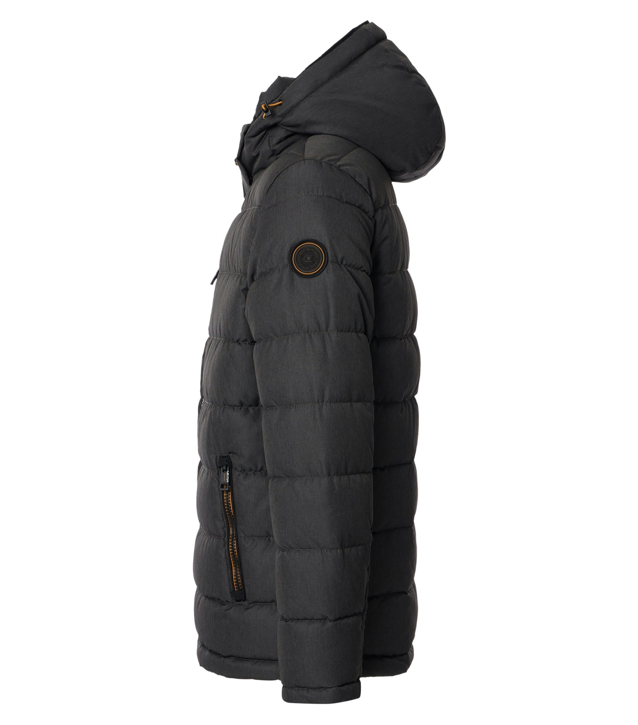 Das Model trägt eine Jacke im uni Muster in der Farbe Schlamm