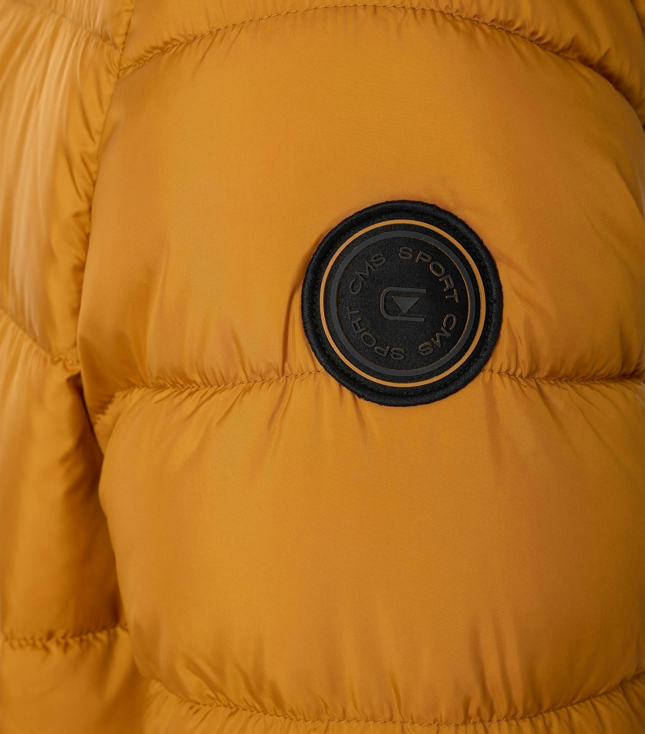 Das Model trägt eine Jacke im uni Muster in der Farbe Gelb