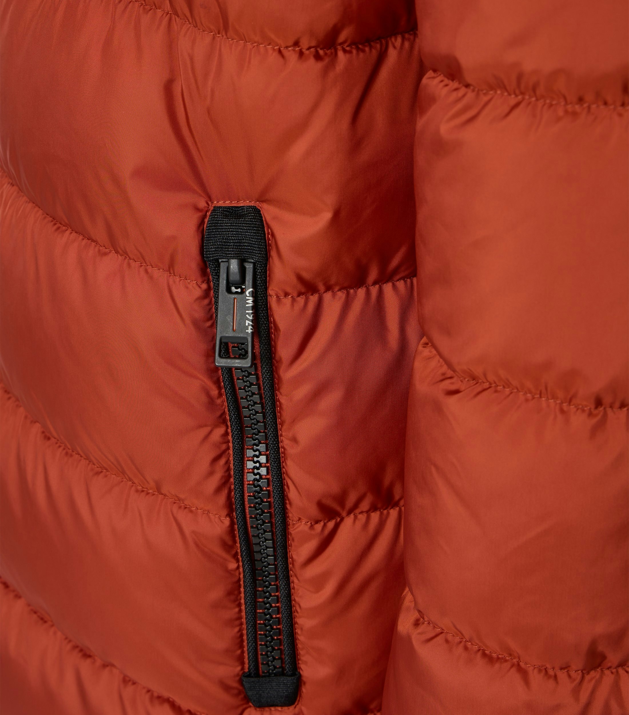 Das Model trägt eine Jacke im uni Muster in der Farbe Orange