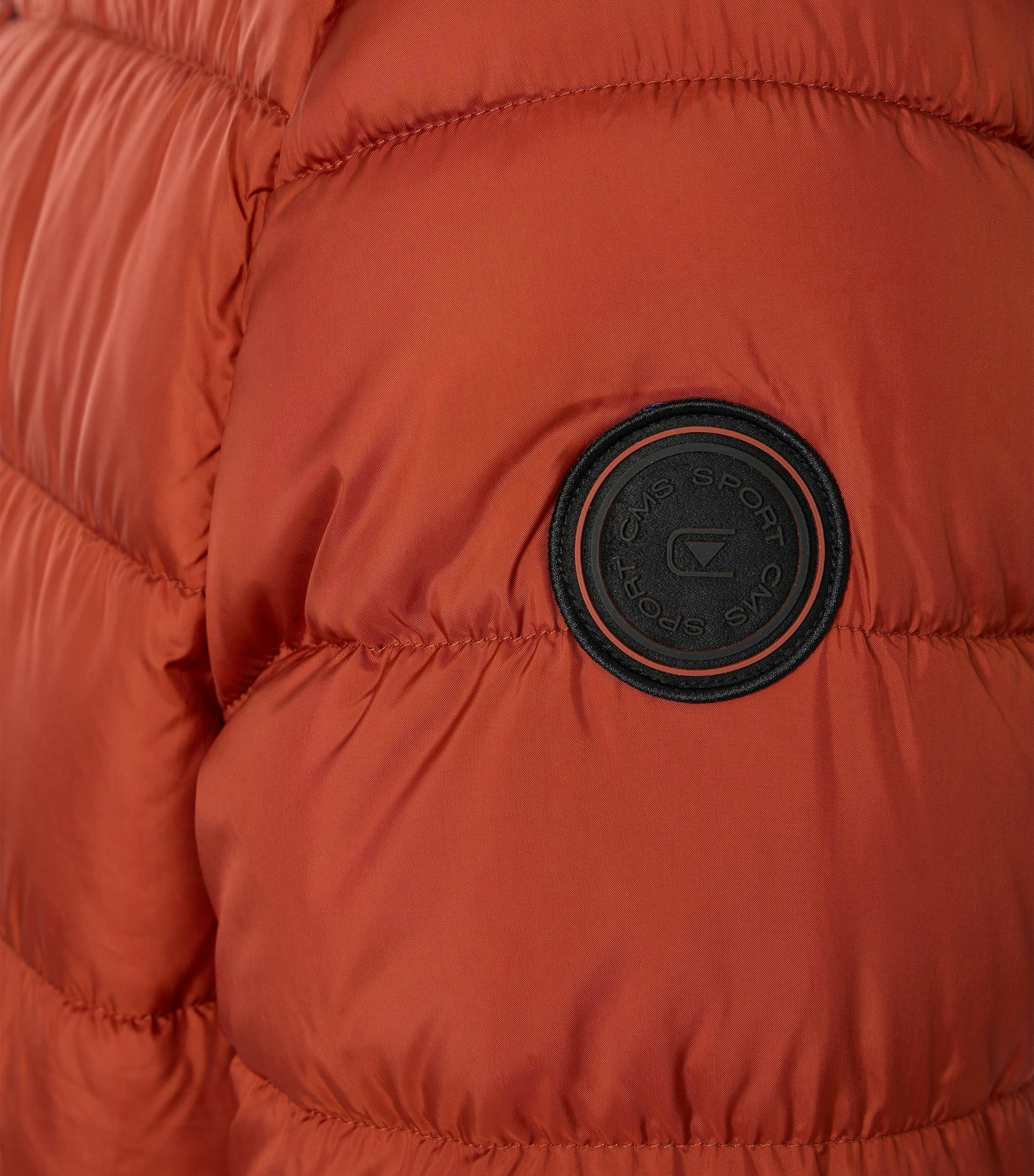 Das Model trägt eine Jacke im uni Muster in der Farbe Orange